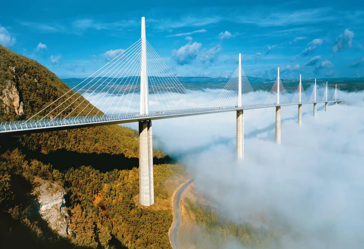 CeJour_Histoire's tweet photo. Il existe un pont français dont le sommet dépasse la Tour Eiffel. Il enjambe une vallée entière, à 270 mètres au-dessus de la rivière, et presque personne ne sait que l'entreprise qui l'a construit en encaissera le péage jusqu'en 2079.

C'est le viaduc de Millau, dans l'Aveyron. Une autoroute suspendue dans le ciel du Massif central, longue de 2 460 mètres, posée sur sept piles d'acier et de béton.

Pendant des années, l'été, la France entière se bloquait ici. Pour descendre vers la Méditerranée, il fallait traverser la petite ville de Millau, et les files s'étiraient sur des kilomètres.

L'idée a semblé folle : franchir la vallée du Tarn d'un seul trait, par les airs. Un ingénieur français, Michel Virlogeux, en dessine la structure. L'architecte britannique Norman Foster lui donne sa silhouette de harpe.

Trois ans de chantier. Le point culminant grimpe à 343 mètres, treize de plus que la Tour Eiffel. Le tablier, lui, pèse quatre fois la dame de Paris.

Inauguré en décembre 2004, il n'a reçu aucune subvention : Eiffage a avancé les 320 millions et se rembourse au péage. L'État, lui, a payé les études et les accès.

Le plus beau pont du monde est français. Et il est en Aveyron.