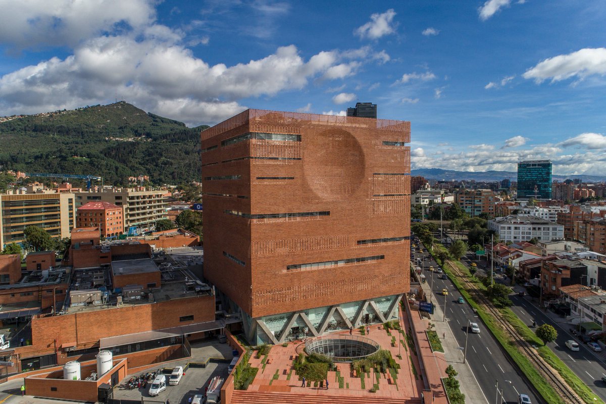 shavnyuyngah's tweet photo. Colombia doesn’t just build with brick. It builds monuments with it.

The University Hospital of the Santa Fe de Bogotá Medical Foundation is an entire tower wrapped in patterned brick, a perforated skin punched with a giant circular motif and long horizontal window slots, all sitting on a base of angular concrete columns that fold like origami. This isn’t a budget material hiding behind plaster. It’s the whole facade, load-bearing and decorative at once, holding up a hospital most cities would have wrapped in glass and called modern.

Meanwhile in Africa, we sit on laterite soil rich enough to fire brick by the ton, coal reserves to burn it with, and centuries of masons who already know how to lay it. And we still build our schools and hospitals out of poured concrete and sandcrete block, importing the very material philosophy Colombia is turning into architecture people fly in to photograph.

Brick was never primitive. We just stopped believing it could be beautiful.

University Hospital of the Santa Fe de Bogotá Medical Foundation | El Equipo Mazzanti
Bogotá, Colombia | Photography: Andres Valbuena, Alejandro Arango, Fredy Fortich
