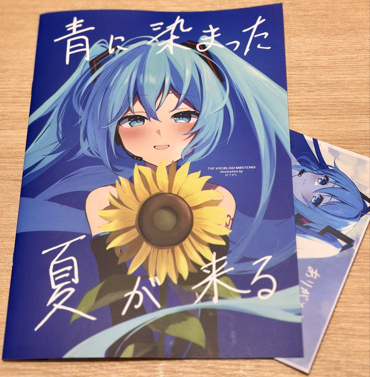 TetriShiro_vpst's tweet photo. ぼうがしさんの新刊
前々回（去年の11月）ボーマスの新刊を購入してからファンなのですが、やっぱ青とか空の表現が抜群に良く、特に向日葵のイラストがやっぱ猛烈に目を引いてて素敵でした。いい。青い曲が描きたくなる素敵な本でした。
あと毎回ポストカードつけてくれて嬉しい。 https://t.co/c92ibb9x1P