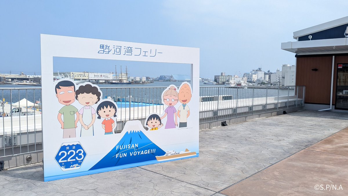 223_ferry's tweet photo. ＼清水港に新しいフォトスポットが登場！📸✨／
清水港乗り場の真上、清水魚市場 河岸の市「いちば館」の２階に、期間限定のフォトパネルが設置されています！ 

 ちびまる子ちゃんたちと一緒にフレームに入って、
 清水港の海と青空をバックに記念撮影が楽しめます😊
フェリーのご乗船前後はもちろん、 
#河岸の市 で美味しい海鮮をお楽しみいただいた際にも、ぜひ立ち寄ってみてくださいね🚢🐟

撮影されたお写真のご投稿もお待ちしております📷✨

#駿河湾フェリー #ちびまる子ちゃん #chibimarukochan #フォトスポット