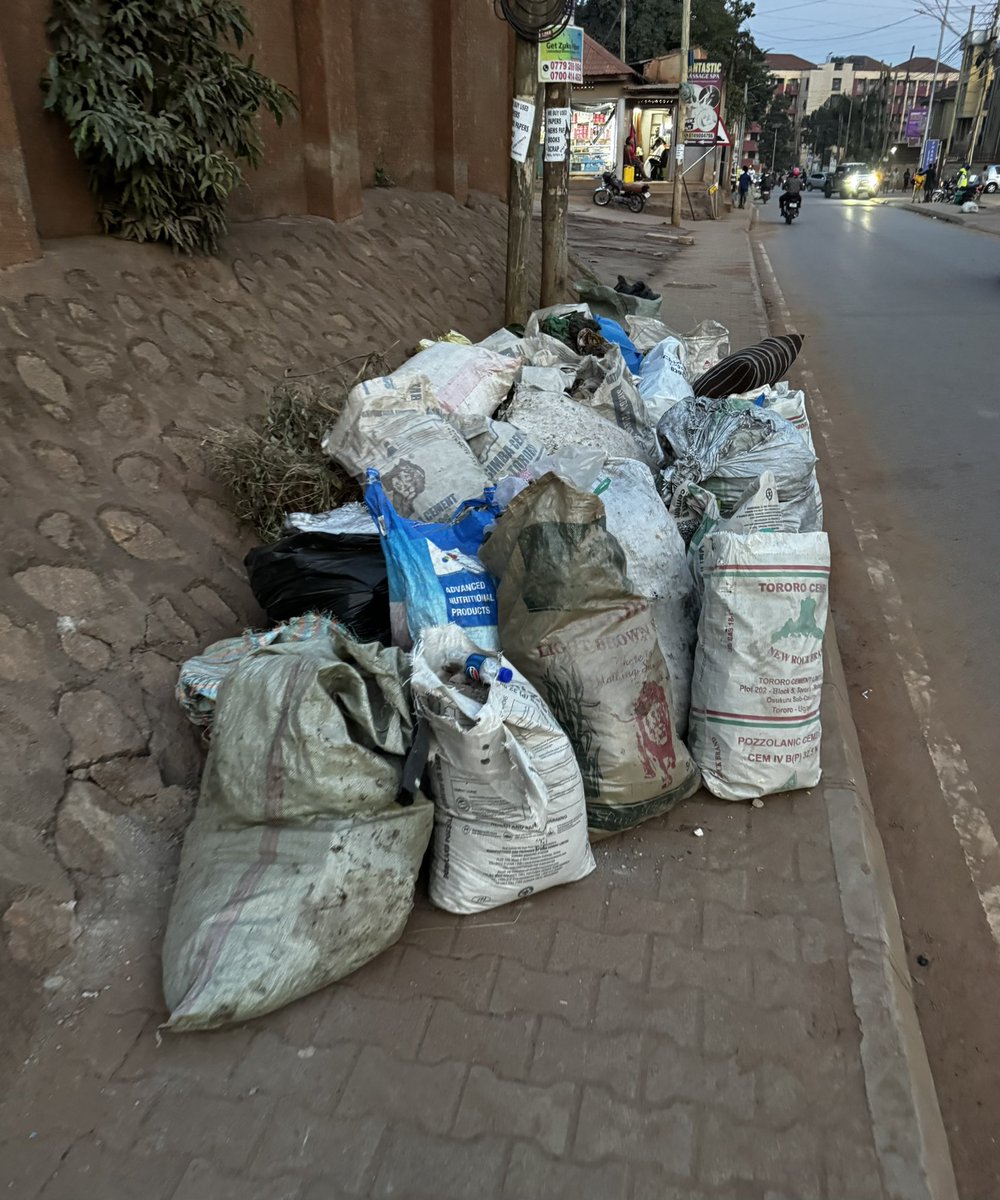 GodwinTOKO's tweet photo. It's 7 pm, hours since @PoliceUg took back their guns, & the @UgandaMediaCent turned off their cameras, yet the rubbish remains where it was left! Some of it blocking the walkway, & pausing a safety hazard for pedestrians! Should it rain in the night, boom!

See the problem of rushing a policy because you want to show power & get social media likes without thinking them through, @KCCAUG & @OPMUganda?!