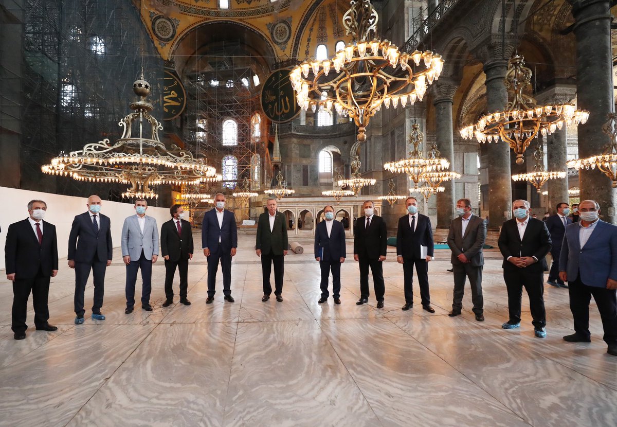 coskunyilmaz66's tweet photo. 24.07.2020
AYASOFYA’DA İLK CUMA
Coşkun Yılmaz

24 Temmuz 2020. Ayasofya’dayım, Ayasofya Camii’nde. 86 yıl aradan sonra kılınacak ilk Cuma namazı için. Namaza 2,5-3 saat var. Gülhane Parkı’ndan camiye doğru yol alırken, tramvay yolunun iki yanına yığılmış, Ayasofya’ya birkaç cm daha yakın olmak için ilerlemeye çalışan on binlere şahit oldum bu küresel salgın (covid 2019) ortamında.

Camiye girenlerde ise ayrı bir duygu, ayrı bir heyecan, ayrı bir his. “Evet, Ayasofya’dayım ve burası gerçekten cami” diyebilmenin mutluluğu ve şahitliği var simalarda. Biraz da gerçeklik merakı, “olabiliyormuş”, “yapılabiliyormuş” güveni… Yıllardır müze olarak ziyaret ettiğim, bir vakit namaz kılmak için içimin eridiği bu mekanda Cuma namazını bekliyorum. 

Bazı dostlarım 2003’te rahmetli Haluk Dursun’un, iftar davetlilerine imkan sağladığı yatsı ve teravih namazının hikayesini büyük bir heyecanla anlatırlardı da onları anlamaya çalışırdım. Hatta O gecenin gündüzünde telefonlaştığımız M. Akif Aydın Hoca. “Ben dün gece öyle bir yerde namaz kıldım ki Kabe’de kılsam bu kadar mutlu olurdum ancak” demişti. Belli ki, daha ötesini söylemeye dili varmamıştı. Oranın neresi olduğu duyulursa kıyamet kopar endişesiyle, ısrarlı sorularıma “Ayasofya” diye fısıldamıştı. Fakir o gece namazı Mekke-i mükerreme’de, Harem-i şerifte eda etmişti. Bu konuşmayı da Kabe-i muazzamaya bakarak yapıyordum. Yine de yüreğim burkulmuştu orada olamadığım için. Böyle bir özlemdi Ayasofya da gizli bile olsa namaz kılmak. 

Yıllarca,  3 Mart 2017’de İl Müdürü olarak tayin edildiğim İstanbul İl Kültür ve Turizm Müdürlüğü’ne bağlı bir birim olmasına rağmen de niyet etmemiştim, edememiştim namaz kılmaya. Hep bir burukluktu gönlümdeki ama vuslatı yaşayamamıştım 3,5 sene boyunca. Ayasofya’da ilk namazım 29 Mayıs 2020 Cuma günü akşam namazıydı. Fetih kutlaması hazırlıkları yapılıyordu. İçeride Fetih Suresi okunacak, Cumhurbaşkanımız Recep Tayyip Erdoğan ile Kültür ve Turizm Bakanımız Mehmet Nuri Ersoy canlı bağlantı kuracaktı. Program televizyonlarda canlı yayınlanacaktı. Müthiş bir heyecandı Ayasofya’da Fetih Suresi’nin okunmasını beklemek. Ayasofya’nın kubbelerinde duvarlarında o sesin çınlamasını, yankılanmasını işitmek. Ne kadar da hasretmişiz böyle bir sese. Bunu şimdi daha iyi anlıyorum. Hazırlıklar devam ederken akşam ezanı okundu. Beş altı arkadaş baktık birbirimize, “Namazı nerede kılacağız?” “Burada kılalım, kimse yok, zaten görevliyiz. Ancak kimse fotoğraf paylaşmasın”. “Doğru”, “program için buradayız, namaz vakti geldi biz de kıldık deriz. Ama duyulmasın sakın” denildi. Ayasofya’da namaz kılıyordum, akşam namazını: 29 Mayıs 2020. Ve o namazın fotoğrafını hala saklıyorum o günkü endişe ve heyecanımla birlikte… 

Ne kadar yavaş, ne kadar hızlı aktı zaman. Televizyonlar, gazeteler, radyolar, iletişim mecraları hep Ayasofya’yı konuştu o günden bugüne. Kaç televizyon programına katıldığımı bile hatırlamıyorum Ayasofya’yı anlatmak için. Kaç gazeteye, dergiye demeç verdiğimi... Hep bir ümit, büyük bir heyecan ve biraz da endişe ile anlattım Ayasofya’yı televizyonlarda, gazetelerde, dergilerde, sosyal iletişim mecralarında. Hep bir beklenti ile. “Bu sefer tamam mı” sorusuna “galiba, evet” diye başlayıp “ama” ile devam eden cümlelerde emin olamamanın ıstırabını yaşayarak… 
10 Temmuz 2020 Danıştay’ın kararını açıklaması ve Cumhurbaşkanlığı Kararnamesi, Cumuhurbaşkanlığımızın 20.53 konuşması… 

Ve gerçek oldu hayaller. Tarih mi bugüne dönüşmüştü, bugün mü tarihe… 86 yıllık bir hasret sona ermiş, Ayasofya tarihi kimliğine yeniden adım atmıştı… Yeniden… Her şey yeniden başladı sanki… Her anın bir hatır��, bir de hatırası vardır. Her mekanın da. Fakat, Ayasofya’nınki başka. Ayasofya ile hatıralarım bir başka tecelli etti bu tarihten sonra. 24 Temmuz yolculuğuna her kademede şahit olmak gibi bir kaderdi benimkisi. Bir tarihçi olarak da bir başka yaşadım Ayasofya’da 86 yıl sonra kılınacak Cuma namazına doğru akan zamanı. Ne kadar not birikti bugüne dair geleceğe taşınacak. Ne büyük bir titizlikle, hassasiyetle, uzmanlık ve istişare ile ilerledi süreç. Herkeste bir merak, herkeste bir tedirginlik. 86 yılık vuslat coşkusu yerine, milletimizin aksine tedirginlik soruları dolaşıyordu basının koridorlarında. Sanki ilk defa cami olacaktı Ayasofya. Sanki ilk defa namaz kılınacaktı burada... Ne kadar hüzün vericiydi bu tür sorulara cevap yetiştirmek, ne kadar acıydı bu tarz sorulara muhatap olmak. “Ayasofya 1453’ten beri bizim ve cami. 86 yıllık bir aradan sonra tekrar eski kimliğine kavuşuyor. Tarihten bu kadar mı koptuk ki bu sorular en önemli gündem maddemizi oluşturuyor? Ayasofya’ya tarihinde en büyük hizmeti yapan milletiz. Onun dini, kültürel, tarihi değerini koruyan, geliştiren ve geleceğe taşıyan da bu millettir. Burası Osmanlı devletinin protokol camisidir ve Osmanlı sultanları buraya hizmet için yarışmışlardır, Ayasofya’ya yepyeni bir kimlik kazandırmışlar ve dört başı mamur bir Osmanlı külliyesine dönüştürmüşlerdir” “Bize ne kadar uzak, ne kadar yakınsın Ayasofya” diye sormadan edemiyordum çoğu zaman. Ama yaklaşıyordu 24 Temmuz. Nasıl bir koşuşturma, nasıl bir heyecan, nasıl bir telaş. İki defa geldi Cumhurbaşkanımız hazırlıkları yerinde incelemek için. 19 ve 23 Temmuz’da. 86 yıllık özleme son veren, gelmez zannedilen tarihi anın inşacısının ziyaretiydi bu. Ve şahitliğim tarihin inşasına, bu inşanın satır aralarına ve satırbaşlarına dairdi. 
 Ne kadar çok şey yaşadık 14 günde bu namazın edası için. Her bir anı “geçmiş zaman olur ki..” tadında. Düşünüyorum da saatlerce anlatılsa yeter mi zaman, yorulur mu insan dinlemekten. “Acaba” diyorum, “acaba ben mi tarihte yaşıyorum, tarih mi bu anda canlanıyor?” 567 yıl önce kılınmıştı ilk Cuma Namazı Ayasofya’da, Haziran 1453’te. Ve 481 sene devam etmişti kesintisiz… 29 Mayıs günü şehre giren ve Ayasofya’da ilk ezanı okuyan Fatih’in, fethin ilk gününde ortaya koyduğu tavır insanlık tarihinin bir ibret levhası gibi okutulmalı aslında. 21 yaşındaki Sultan’ın secdesini, başından aşağıya saçtığı toprağı, canları ve malları ağzından çıkacak bir kelimeye bağlı İstanbul halkına müsamahasını, Ayasofya’yı seyretmesini canlandırdım gözümde. Ayasofya’nın ilk namaza hazırlanışı için koşuşturmaları, Akşemseddin’in o ilk tekbiri alışını, İstanbul’da ilk cumayı için fatihlerin akın akın Ayasofya’ya gelişini tasavvur ediyorum. Bir tayyi mekan hayali gibi bizimkisi. Ayasofya’da müezzinlik de yapan Evliya Çelebi’nin o günü, ilk cumayı anlatan sesi yankılanıyor kulaklarımda: “Bütün Müslüman gaziler hazır olup, salalar okunup, müezzinler “Şüphesiz Allah ve melekleri” âyetini okuyunca Akşemseddin ve Kara Şemseddin hazretleri kalkıp Sultan Mehmed’in koltuğuna girdi. Akşemseddin imamesini Fatih’in başına giydirip, imamesi üzerine bir ablak turna teli sokup ve eline bir kılıç verdi. Sağ tarafında Akşemseddin, sol tarafında Kara Şemseddin olduğu halde tazimle Mehmed Han’ı minbere çıkarıp, padişah davudî bir sesle ‘Elhamdü lillâhi Rabbi’lâlemîn’ deyince bütün Müslüman gaziler feryat ettiler. Sultan, âdet olduğu gibi hutbeyi eda ettikten sonra teberrüken Akşemseddin hazretleri Sultan Mehmed Han’dan izin alıp imamlık yaptı”.
“Neler yaşanmıştı 1 Haziran 1453’te?... Keşke, o anı yaşayan birisi yazsaydı sayfalarca ve ayrıntılı bir şekilde olayları, konuşmaları, tavırları ve hisleri. Ve şimdi okusaydım ben onları, belki daha iyi idrak ederdik bugünleri ve o anı”. Söylemesi kolay ama yazılması öyle değilmiş. “Yazmalısın ey tarihçi” diyorum “yazmalısın ki unutulmasın bu anlar ve bu zamana gelişler. Yaşayamadığının eksikliğini yaşatma zamanına tanık olmak isteyenleri…” Ezanlar okunmaya başladı dört ayrı minareden birbiriyle münavebeli. Ve Sultanahmet Camii ile karşılıklı. 86 yıl sonra Ayasofya’da kılınacak ilk Cuma namazı için... Ve ben hala anlamaya çalışıyorum hangi zaman karesinde yer aldığımı? Neredesiniz ey kelimeler, ey kağıt, ey kalem? Neredesiniz ve neden bu kadar acizsiniz?...” Evet, 86 sene sonra, Ayasofya’nın, 29 Mayıs 1453’tekine benzer şekilde, tarihe büyük bir not düşülerek bir Cuma namazıyla birlikte kapıları cami olarak yeniden açıldı, Bu sadece tarihi bir hadise değil, tarihe hürmetin bir ifadesi ve tarihi bir iddiadır. Kolay bir iş değildi. Fakat tarihe ve Türkiye’ye yaraşır bir üslup, ihtimam, vakar ve ihtişamla açıldı. 100 yıllık bir hikayenin finali Ayasofya’ya, Fatih’e, fethe ve milletimize yaraşır sahneydi.
ÜSKÜDAR DERGİSİ, 2020/1