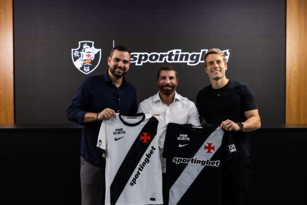 NewsAlmirantee's tweet photo. A parceria entre Vasco e Sportingbet pode render até melhorias no CT Moacyr Barbosa.

Um dos principais diferenciais do acordo será o lançamento de um programa inédito de engajamento da torcida. Ao longo do ano, os vascaínos serão convidados a cumprir uma série de missões dentro de uma jornada gamificada, em uma landing page própria.

À medida que os objetivos forem alcançados coletivamente, novos benefícios e investimentos serão desbloqueados para o clube.

Na primeira missão, já disponível no site, os torcedores devem escolher o Vasco como clube do coração na plataforma da Sportingbet (não é necessário apostar). Com a meta atingida, o Centro de Treinamento ganhará melhorias.