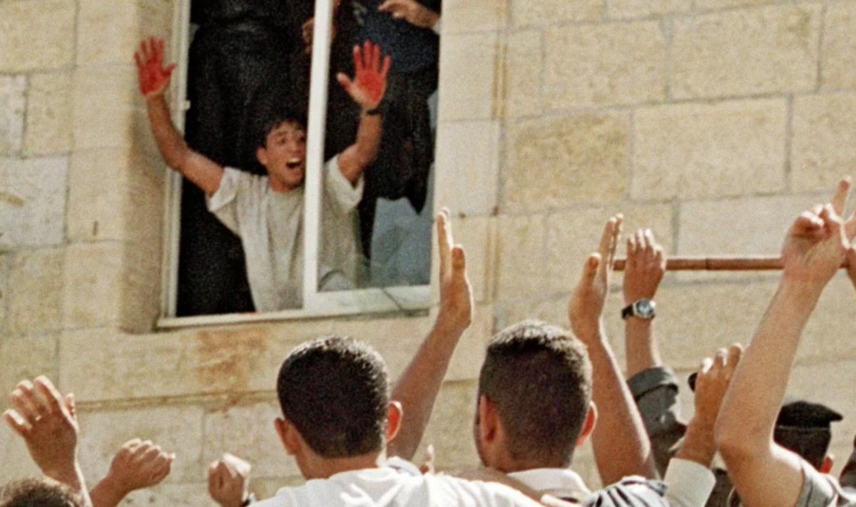 MartienPennings's tweet photo. Dit is het politiebureau van Ramallah op de Westelijke Jordaanoever in het jaar 2000. De foto toont een moment nadat een Palestijnse menigte twee verdwaalde IDF soldaten had gelyncht en hun lichamen had verminkt. Aziz Salha toont trots zijn met bloed bevlekte handen. Een RED HAND-speldje is sinds 7 oktober een symbool dat door ‘pro-Palestijnse activisten’ in het Westen wordt gebruikt. Salha werd in 2024 gedood in Gaza. https://t.co/hTLX1yzfhH