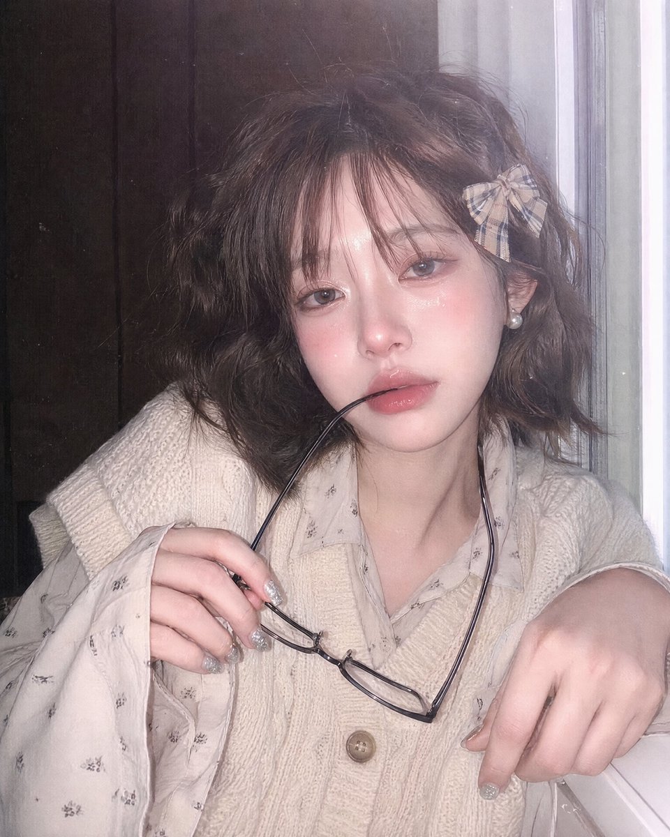 doctorwasif's tweet photo. Made with Chatgpt 2

{
  "style": "Photorealistic, Japanese retro pin-photo, soft focus, mobile flash, CCD texture, subtle noise, low contrast, no anime",
  "ratio": "9:16",
  "composition": "Close-up half-body, slightly high frontal angle, subject slightly right, face dominant",
  "background": "White window frame right, dark wall left",
  "subject": {
    "skin": "Ivory, pink blush, fine glitter",
    "expression": "Shy, moist eyes, glossy parted lips holding black-rimmed glasses",
    "hair": "Short wavy dark brown, airy bangs, plaid bow clip",
    "accessories": "Pearl earrings, glitter nails",
    "pose": "One hand lifts glasses, other in foreground, slight forward lean"
  },
  "outfit": "Beige chunky knit vest over a light printed shirt",
  "lighting": "Cool window light + frontal flash, soft haze, slight overexposure",
  "details": "Dewy skin, glossy lips, glitter reflections"
}