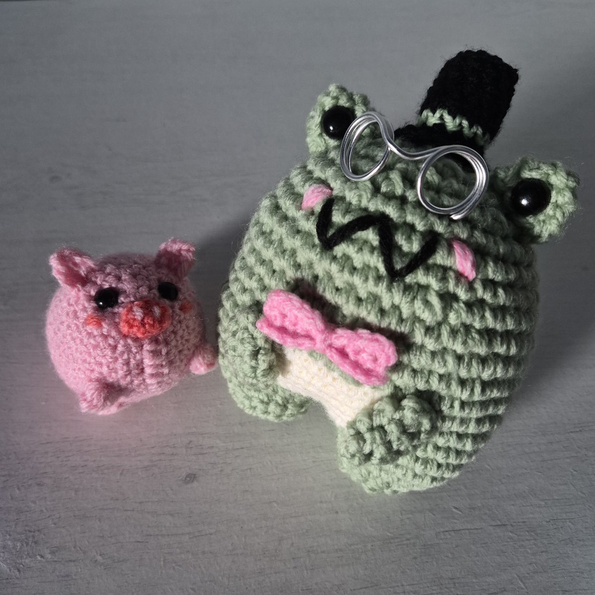 DinahMBishop's tweet photo. Crochet frog and mini pig! - Frog placed 3rd at #HeckingtonShow 🥉

Patterns - KeinMaker
I only changed the frogs decorations / accessories , since I wanted something different than a crown.. So I made a little top hat, a bowtie and bent some wire for his tiny glasses! https://t.co/CkxplvVOmm