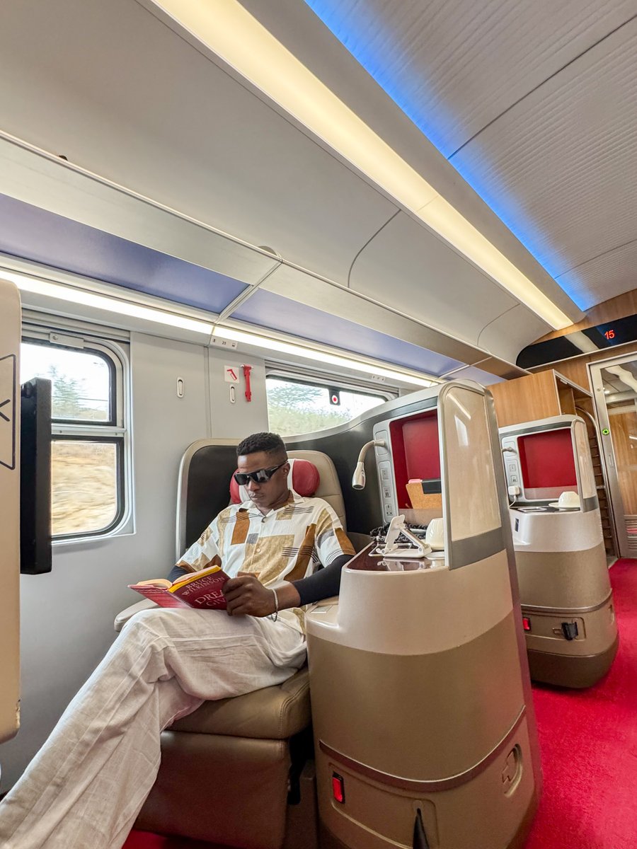 Ssenyonyiderick's tweet photo. Gliding from Nairobi to Mombasa on the
SGR🇰🇪

I couldn't help imagining it... a train from Kisoro to Kampala, Gulu to Kampala, one day, in this lifetime hopefully.

Anyway, let me tell you guys about the actual experience, Nairobi to Mombasa is nearly 500km, in about 5 hours. 

The train cuts straight through Tsavo, which means and I am not exaggerating, you can spot Elephants from your window seat.

A commute that doubles as a game drive.

The coaches are clean, the seats, I mean check the pics🙌, the whole thing runs on time.

They call it the Madaraka Express, I am going to call it a preview... of what East Africa could be.
