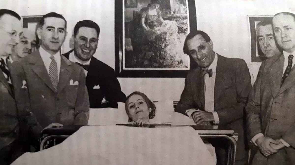 infobae's tweet photo. LA ENFERMERA QUE CUIDÓ A EVITA EN SU LECHO DE MUERTE: “YO LE CERRÉ LOS OJITOS, YA NO IBA A DESPERTAR; PERÓN LLORABA COMO UN NENE” | Por Julieta Roffo

María Eugenia Álvarez tiene 99 años. Asistió a la Primera Dama cuando votó por primera vez y en sus últimos días, cuando el cáncer ya era irreversible.

La reconoció por los ojos. Algo de esos ojos verdes cautivaron a Eva Perón, que, cuando su salud se deterioraba de manera irreversible, le dijo a su marido, el Presidente de la Nación: “Que venga a la chica de los ojos verdes”. Hablaba de María Eugenia Álvarez, que en 1952 tenía 23 años y que había visto por primera vez a Evita dos años antes, en el Hospital Rivadavia, donde se formaba como enfermera.

Eva había ido a visitar a algunas trabajadoras de la salud que dependían de la fundación que llevaba su nombre y que habían tenido un accidente. Allí, en el hospital de Recoleta que quedaba a apenas metros del Palacio Unzué, Eva le estrechó la mano a María Eugenia por primera vez. Ninguna de las dos sabía lo que les deparaba el futuro: la enfermera iba a ser, algunos meses después, quien le cerrara los ojos a Eva en su lecho de muerte.

“Yo tenía la vocación de ser enfermera desde siempre. Cuando era chica a iba a la escuela, en el recreo jugaba a curar, a cuidar pacientes. Después, una hermana mía se enfermó y ahí vi de cerca el trabajo de las enfermeras, y me convencí para siempre”, le cuenta ahora María Eugenia Álvarez a Infobae. Tiene 99 años y vive en una residencia geriátrica de Monte Grande. Se puso, para esta entrevista, un pañuelo con el retrato de la mujer que protagonizó la historia argentina del siglo XX y a la que ella asistió hasta el final.

🔗https://t.co/PF3DSAByyj