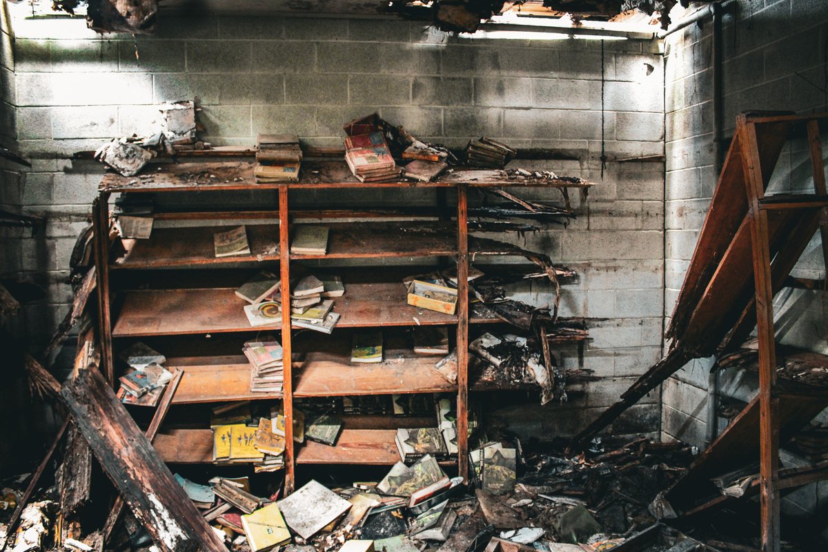 LykinsPhotos's tweet photo. https://t.co/SAkHPf9sp5 - This school sits alone in an open field, still resting on its original concrete foundation. Most of the roofs have caved in, leaving heaps of broken timber, twisted metal, and open sky above what used to be classrooms and hallways. Moving through the building was slow and careful work—downed beams, soft spots in the flooring, and thick vines and brush force you to pick your path.