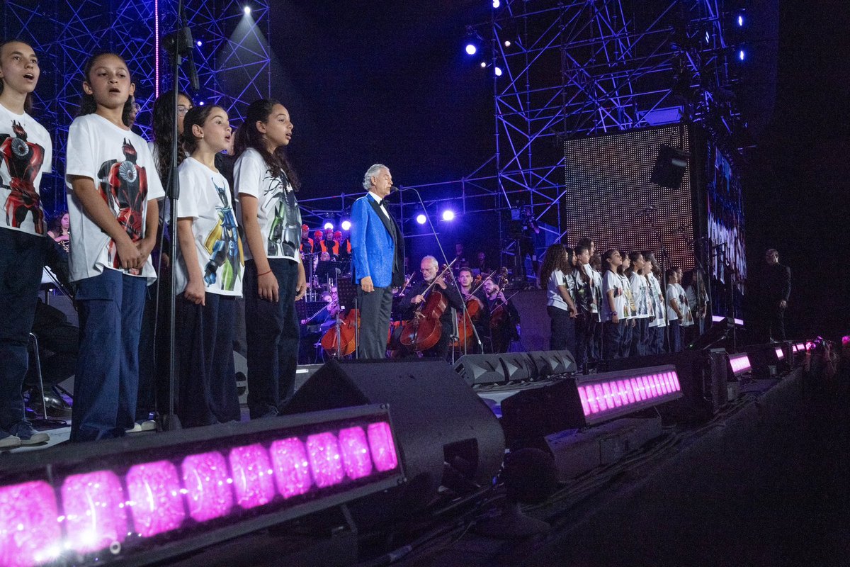 abfoundation's tweet photo. "Thirty years ago, Romanza marked my first step onto the world stage. Last night, on the stage of the Teatro del Silenzio, the world came to sing with me.​

The voices of the young ABF Voices of choristers, from Uganda, the Holy Land, Camerino, and the Rione Sanità in Naples, rose alongside mine in several pieces, while Veronica remained close to them behind the scenes, watching over their emotions with a mother’s care.​

There, among the hills where I was born, their singing, so full of wonder, energy, and life, seemed to me the sure promise of better days to come.​

Their journey now continues to Rome, and our gratitude goes with them."​

@AndreaBocelli