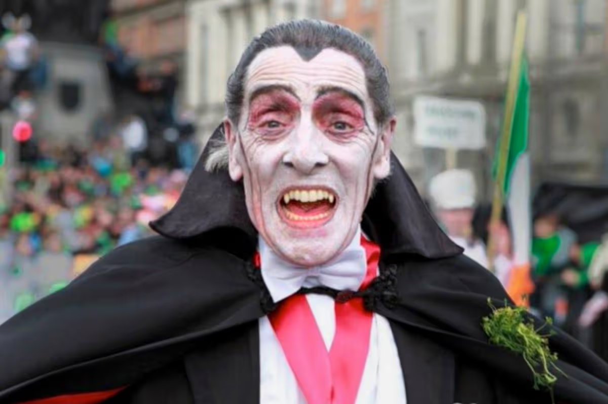 RobLooseCannon's tweet photo. Dublin has produced two vampires I`ve had to pleasure of meeting, and Paddy Drac was by far the more charming. Born Patrick Finlay in 1945, he became a beloved fixture of Dublin life for half a century. But this creature of the night was more obsessed with giving charity and hugs than taking blood. 

His legend began in 1969 whilst on a jaunt to Dalkey where a friend noting his chiselled cheekbones which a modern day Looksmaxxer would envy. But being an Irish mate instead of calling him handsome he remarked that he looked like bleedin Dracula. 

Soon after, a local travel agent hired him to don a cloak and fangs to promote flights to Transylvania, a tongue-in-cheek act that planted the seed of a persona that would capture the imagination of St Patrick's Parade audiences for decades.

Paddy Drac’s first public appearance was chaotic and improvised. He sneaked into the Paddys Day parade with a homemade cloak and paper fangs. Some say it was 1968, others 1969. Whatever the year he became a parade fixture for 49 consecutive years, building his fanbase and becoming a highlight for kids and adults and people watching at home. Getting a squeeze of him was as good as meeting an "official" celebrity.

In his everyday life, when not being the prince of darkness, Patrick Finlay worked as an undertaker for Rom Massey & Sons, later as a porter at Tallaght Hospital. At home in Tallaght, he lived in a gaff he christened “Alucard", Dracula spelled backward. 

And it was his charity work that cemented his legend. Paddy Drac raised tens of thousands for children’s charities, especially those supporting children with special needs. He was also a fixture at the Dublin Taxi Drivers’ Outing for children.

In 2017, those real blood suckers in Dublin City Council briefly tried to clip his bat wings. Security changes initially barred him from the St. Patrick’s Day Parade, igniting a public outcry that reinstated him as a guest of honour. 

A tribute mural in Tallaght, part of the Dublin Canvas project, immortalises his image. The Irish band The Pale penned a musical ode to him, and in 2018 Dublin City Council Culture Company officially recognised him as a “Local Hero.”

Patrick Finlay passed away in April 2019 at 74. The funeral of this beloved gentleman and character drew a massive crowd, and in accordance with his wishes also raised thousands for charity, that last one being the Irish Cancer Society https://t.co/Pa6k48ZNIj
