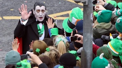 RobLooseCannon's tweet photo. Dublin has produced two vampires I`ve had to pleasure of meeting, and Paddy Drac was by far the more charming. Born Patrick Finlay in 1945, he became a beloved fixture of Dublin life for half a century. But this creature of the night was more obsessed with giving charity and hugs than taking blood. 

His legend began in 1969 whilst on a jaunt to Dalkey where a friend noting his chiselled cheekbones which a modern day Looksmaxxer would envy. But being an Irish mate instead of calling him handsome he remarked that he looked like bleedin Dracula. 

Soon after, a local travel agent hired him to don a cloak and fangs to promote flights to Transylvania, a tongue-in-cheek act that planted the seed of a persona that would capture the imagination of St Patrick's Parade audiences for decades.

Paddy Drac’s first public appearance was chaotic and improvised. He sneaked into the Paddys Day parade with a homemade cloak and paper fangs. Some say it was 1968, others 1969. Whatever the year he became a parade fixture for 49 consecutive years, building his fanbase and becoming a highlight for kids and adults and people watching at home. Getting a squeeze of him was as good as meeting an "official" celebrity.

In his everyday life, when not being the prince of darkness, Patrick Finlay worked as an undertaker for Rom Massey & Sons, later as a porter at Tallaght Hospital. At home in Tallaght, he lived in a gaff he christened “Alucard", Dracula spelled backward. 

And it was his charity work that cemented his legend. Paddy Drac raised tens of thousands for children’s charities, especially those supporting children with special needs. He was also a fixture at the Dublin Taxi Drivers’ Outing for children.

In 2017, those real blood suckers in Dublin City Council briefly tried to clip his bat wings. Security changes initially barred him from the St. Patrick’s Day Parade, igniting a public outcry that reinstated him as a guest of honour. 

A tribute mural in Tallaght, part of the Dublin Canvas project, immortalises his image. The Irish band The Pale penned a musical ode to him, and in 2018 Dublin City Council Culture Company officially recognised him as a “Local Hero.”

Patrick Finlay passed away in April 2019 at 74. The funeral of this beloved gentleman and character drew a massive crowd, and in accordance with his wishes also raised thousands for charity, that last one being the Irish Cancer Society https://t.co/Pa6k48ZNIj