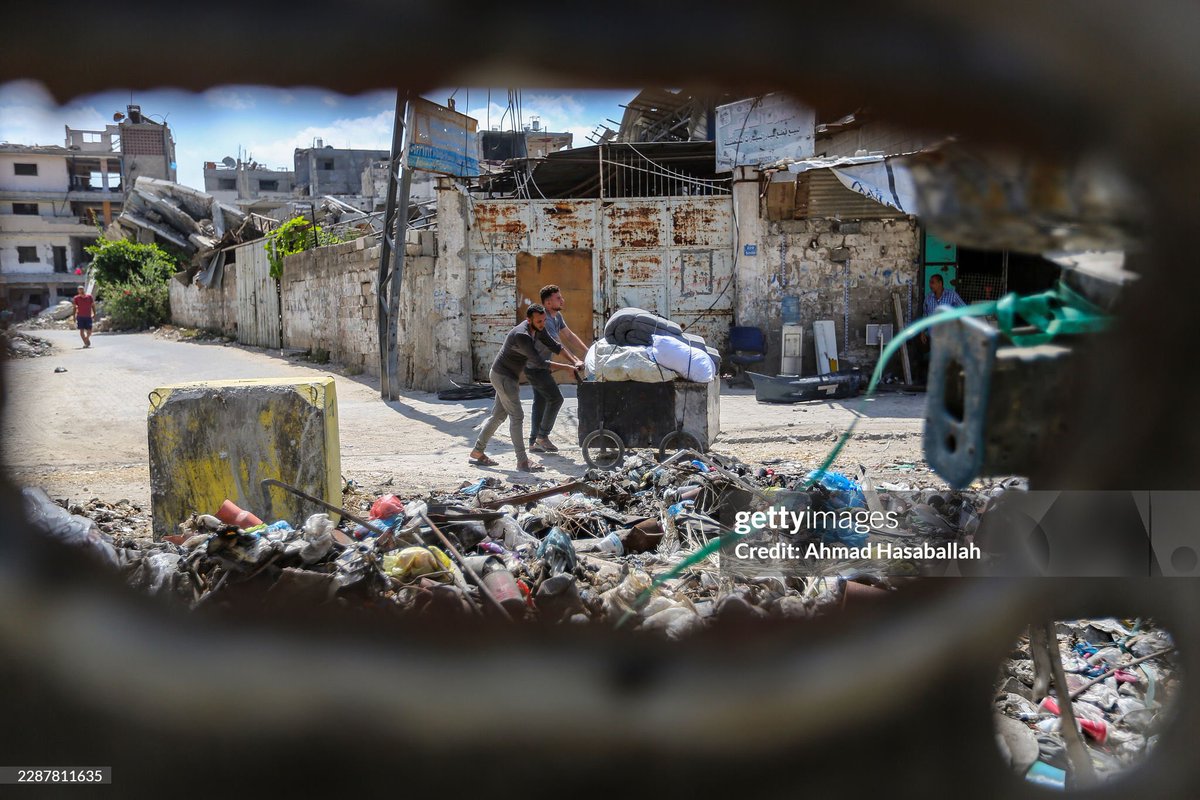 AhmadHasaballa3's tweet photo. Palestinians walk along a debris-laden street next to a yellow concrete blocks marking the 'Yellow Line' on July 27, 2026 in the Tuffah area of Gaza City, Gaza. Residents fled the area after Israel moved its so-called 'Yellow Line' of control to Salah al-Din Road. @GettyImages https://t.co/EeV4QFILJr