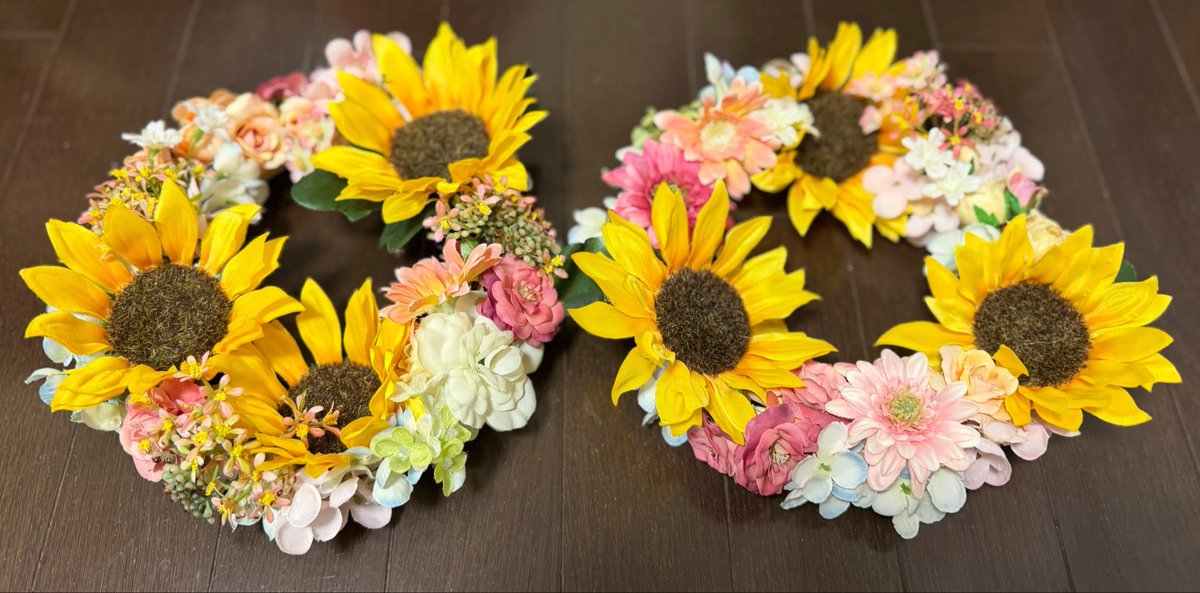 AI_think_child's tweet photo. 夏をテーマにしたリース作り🌻✨

それぞれ好きな花を選びながら自由にデザイン😊

「ここがいいかな？」
「やっぱりこっち！」

花の向きや角度、色の組み合わせにもこだわりながら、何度も並べ替えていました。

同じ材料を使っても、それぞれ違った雰囲気に。

グルーガンは熱いので、取り付けは大人がお手伝いました。
夏らしいお気に入りの作品になりました☺️🌼