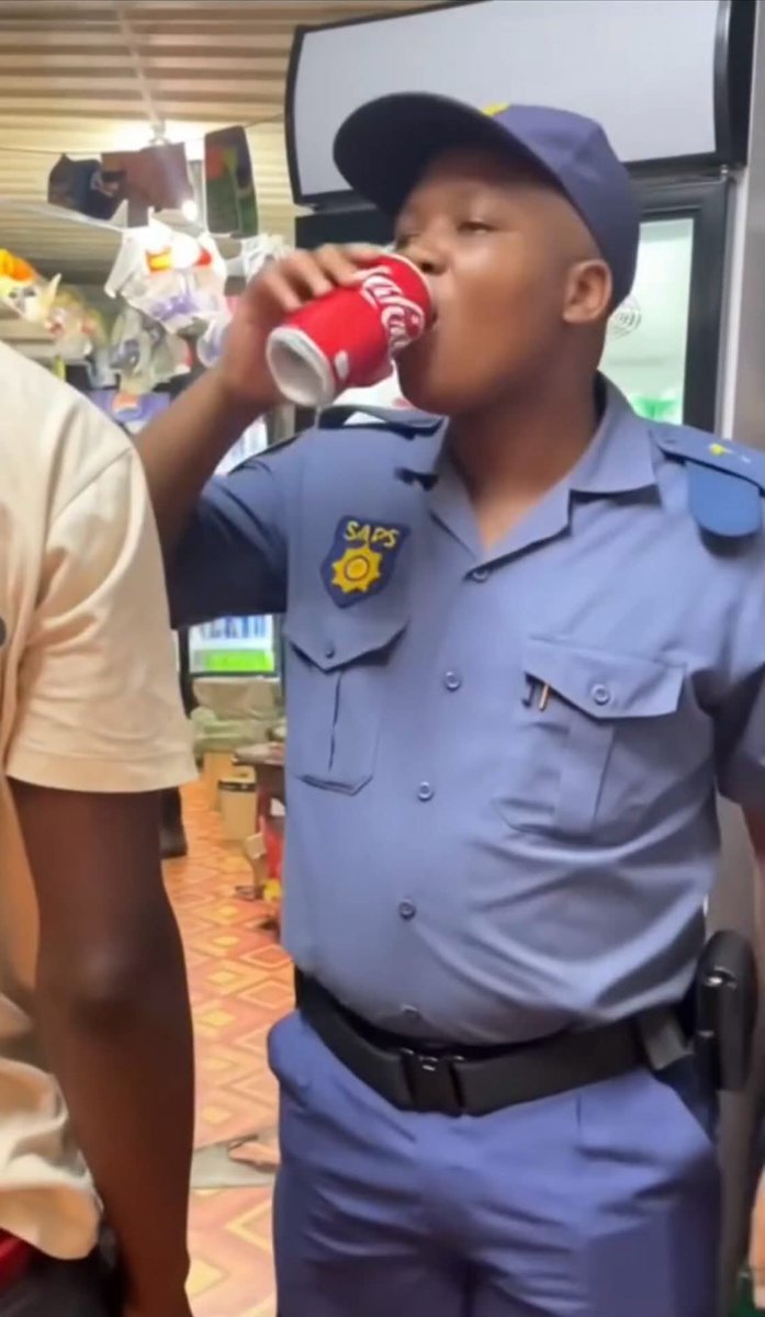 NewsunplugSA's tweet photo. Who will police the police: A #SouthAfrican cop captured on camera joining looters at a shop, he opened a fridge and helped himself with a coke. https://t.co/tI77lA2wjE