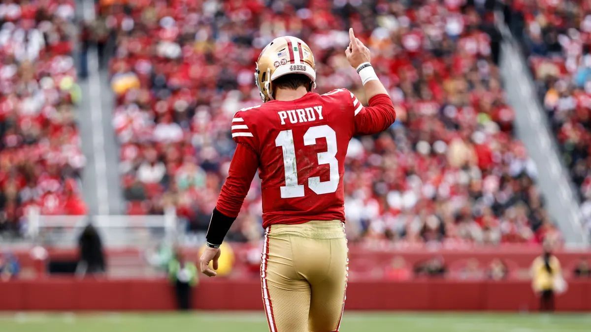 FantasyBowl's tweet photo. Si dejas pasar a los QBs elite en las primeras rondas de tu draft de Redraft, Brock Purdy es el objetivo perfecto para la estrategia de Late-Round QB 

1. Eficiencia Top a costo de remate,a pesar de que la narrativa insiste en encasillarlo como "QB de sistema", la realidad en Fantasy es muy simple: cuando juega, produce. Se proyecta con un ADP rondando entre la 9.ª y 11.ª ronda (QB12-QB14), lo que te permite llenar tu roster con WRs y RBs estelares temprano.

2. Techo real de QB1 (No solo es un piso seguro) Olvídense de que es un passer estático. En sus últimos 24 partidos promedia más de 19 pts por juego, sumando yardas por tierra y anotaciones cuando la jugada se rompe. Todo esto dentro del esquema de Shanahan y con un contrato asegurado de $265M que le da respaldo total en San Francisco.

El Factor de Riesgo para Redraft: Historial de lesiones: El año pasado se perdió partidos y eso asusta a los managers.

Calendario de Fantasy Playoffs: El tramo final de la temporada luce exigente contra defensas duras.

Veredicto para 2026:Si buscas maximizar el valor de tus primeras 6-7 rondas cargando talento en posiciones de habilidad (RB/WR/TE), Purdy te da una producción de QB1 de alto rendimiento a precio de QB2. Compra el descuento en tus borradores.

 #FantasyFootball #Redraft #SF49ers #NFL2026