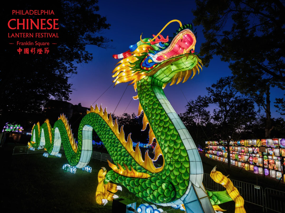 A large dragon lantern glows at night in Franklin Square. Logo for the Philadelphia Chinese Lantern Festival.