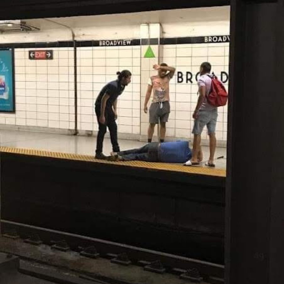feelgoodtale's tweet photo. This afternoon, I had the scare of my life. When my subway train stopped at Broadview station, I heard a faint voice calling out, “Help, help me, please.” It didn’t seem to come from anyone in the car, so I stood up and looked out onto the platform.

Suddenly, I saw a man lying on the tracks. He was blind and had fallen, injuring himself. Without thinking, the man next to me, who you see in the photo wearing the animal shirt, jumped down onto the tracks to help him. Luckily, two other men also rushed to help, and everything turned out okay.

Please share this photo. These men need to be recognized as heroes. If they hadn’t acted so quickly, the situation could have been much worse.

Credit: Julie Caniglia