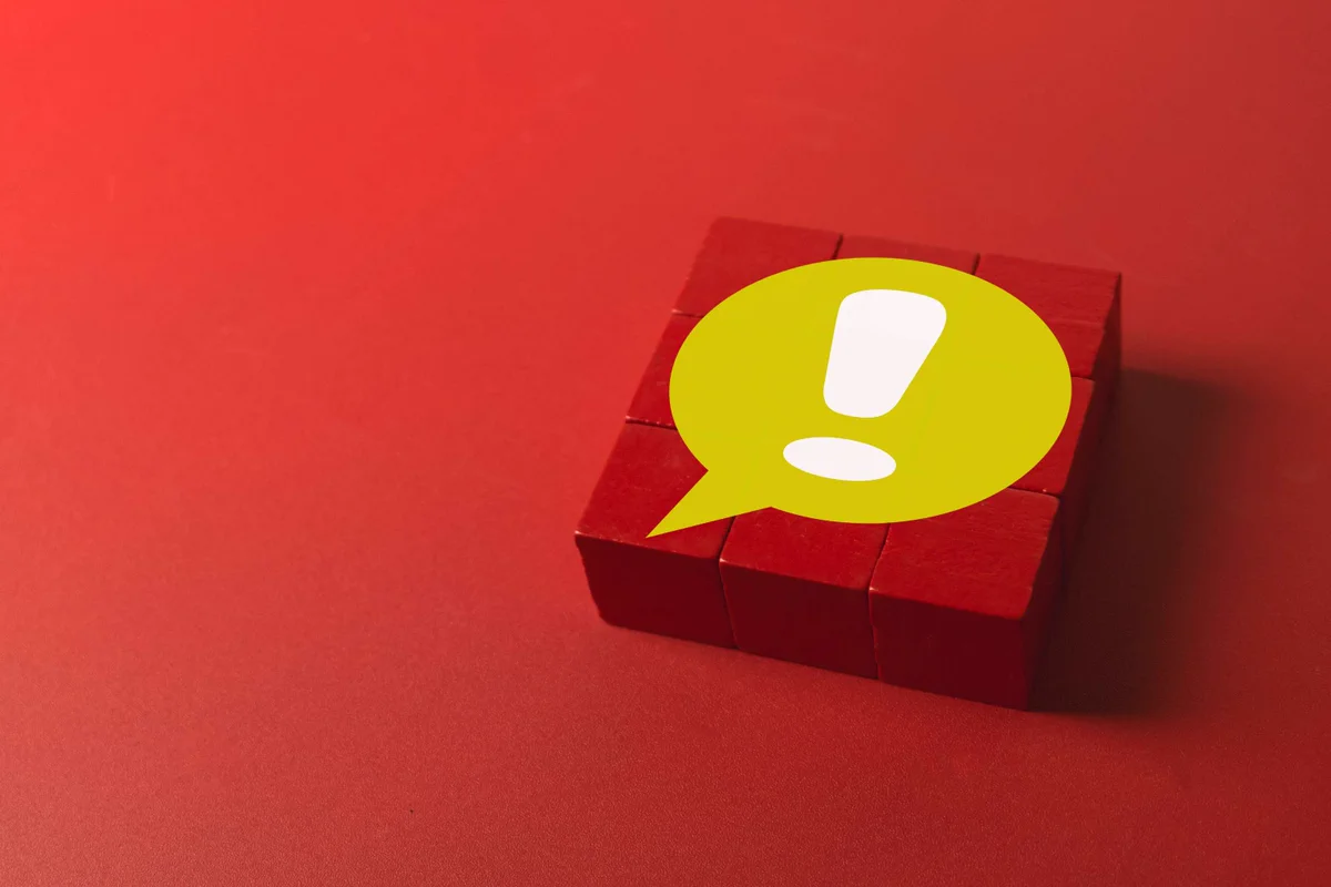 Yellow speech bubble with white exclamation mark on a red background. 