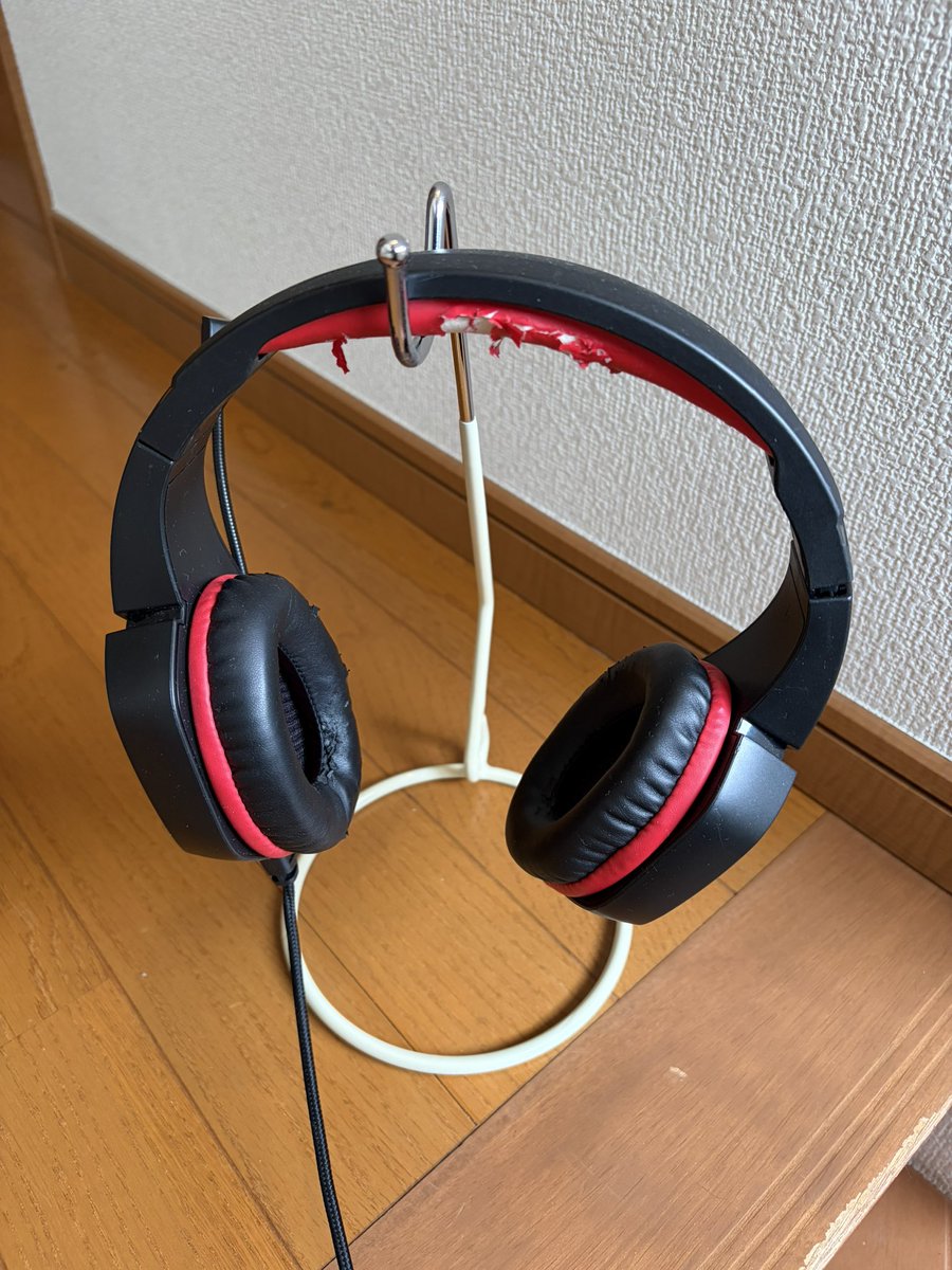 GGy9j's tweet photo. 職場、テレワークで使うヘッドセット。
何かとケーブルが絡まるのだが😵‍💫
（会議で音飛びが怖いので有線愛用）

妻に話したら、ヘッドセットスタンド買ってきてくれた。

ダイソーのバナナスタンド😆
110円なのに超便利 https://t.co/uvelKJHdtW