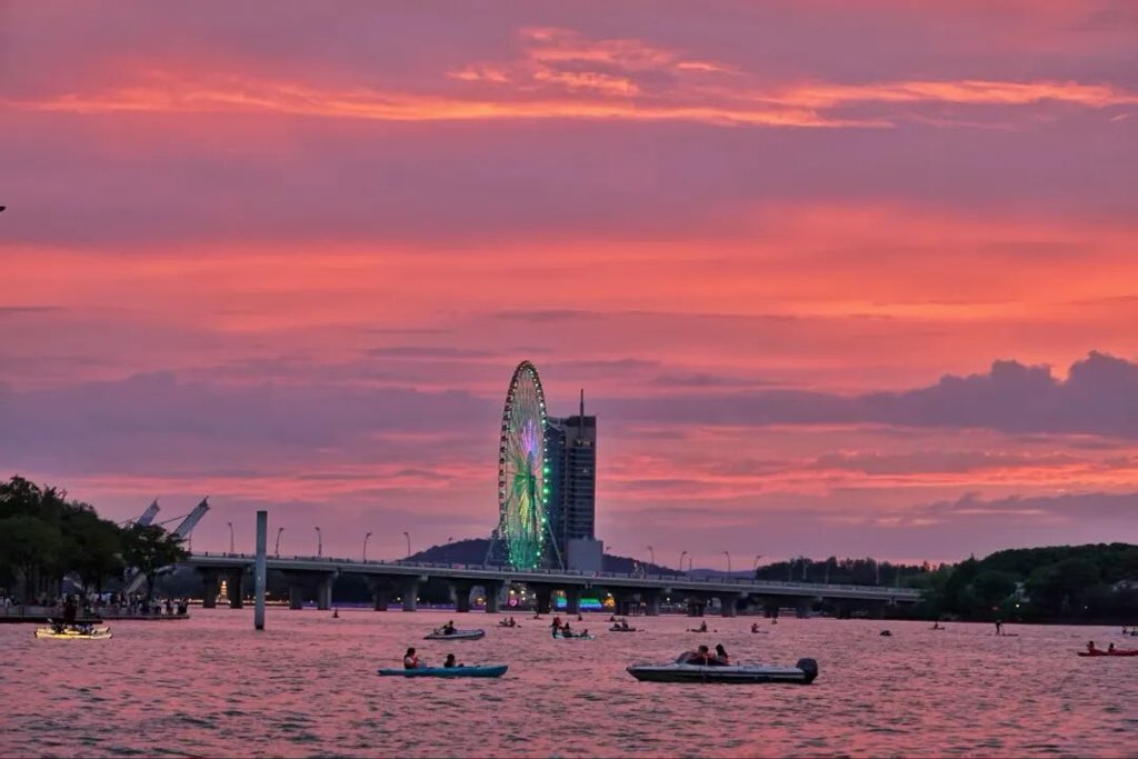 WuxiDailyICC's tweet photo. Summer evening breezes carry floral fragrance. Crowds gather at MixC west platform to admire Lihu Lake’s orange sunset at dusk.

#WuxiLife #LihuLake #WuxiSunset #SummerVibes #CityView https://t.co/lhvCNCA1XI