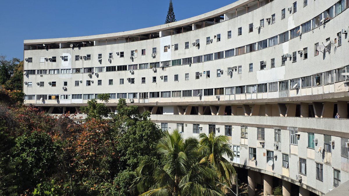 alejandrocsome's tweet photo. Hoy fuimos a conocer un conjunto residencial de vivienda social de los años 50s en Rio de Janeiro: El Conjunto Residencial Marquês de São Vicente.

Eduardo Affonso Reidy proyecto el volumen curvo de 330 unidades para reubicar a las familias de las favelas removida de Gavea en ese mismo barrio. El único bloque construido de cinco proyectados, permitieron ser un importante capítulo de la "Habitación Popular" en Rio de Janeiro por saldar su deuda historica con una parte de la sociedad desplazada por los daños colaterales de la colonización, de las guerras imperiales, de la esclavitud, de las epidemias y revueltas sanitarias, de la geografía que asedia.

No alcanzó, no alcanza y posiblemente no alcance, pero la historia pide no abandonar e intentar, porque es el pasado pero tambien el futuro el que necesita que no se claudique.

¿Que sería de la estantería de intentos sin figuras como Carmen Velasco Porthino? Ingeniera Civil, hija de una migrante boliviana y un gaúcho del sur, que se enfrento a todas las barreras que le impusieron sus colegas para ejercer y que la llevo a estar al frente del Departamento de Habitación Popular para no dejar de intentarlo.

Un conjunto que copia la cota de nivel del morro situndo la planta de accesos a los departamentos en un sector privilegiado del paisaje. A la derecha el morro lleno de mata atlántica, a la izquierda la pendiente y el paisaje dominado por el Cristo Redentor.

Pensar el mejor lugar posible para que todos los dias la gente mas desfavorecida pueda tener una parte de esa realidad que para otros (y durante generaciones) ya es costumbre: imaginar un futuro posible.

Nunca se trató -ni se trata- de utopías. Por el contrario, se trata de unir un tejido real rotos y desgarrado con lo que cada uno puede dar.

En este caso: una casa.
Seguimos caminando.