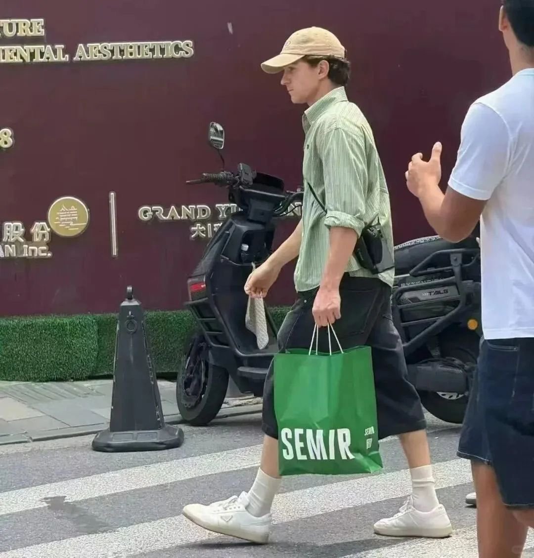 PoohChaiKonNun's tweet photo. Tom Holland ได้กลายเป็น Brand Ambassador ให้กับแบรนด์ SEMIR ของจีนโดยไม่ตั้งใจหลังจากเขาเดินทางไปเซี่ยงไฮ้เพื่อโปรโมทหนัง Spider-Man:Brand New Day และเขาได้ไปเดินเล่นในเมืองเมื่อวันที่ 23 กรกฎาคม และด้วยอากาศที่ร้อนจัดเจ้าตัวเลยแวะซื้อกางเกงขาสั้นที่ร้าน แล้วใส่ออกมาเลย โดยคอลเลคชั่นที่เขาซื้อ คือ รุ่น Summer 2026 ราคาปกติ 239 หยวน แต่มีโปรโมชั่นอยู่เลยซื้อได้ราคา 159 หยวน 

พอเขาเดินออกจากร้านมีคนถ่ายรูปไว้ได้แล้วกลายเป็นไวรัลไปทั่วประเทศจีน จนกางเกงรุ่นนี้ขายดีจนหมดเกลี้ยง! จนแฟน ๆ เรียกร้องให้เติมสต๊อกด่วน 
และแถมเพิ่มความดังให้กับแบรนด์เพราะแฟนๆ แห่ถ่ายรูปกับถุงแบรนด์เลียนแบบน้องทอมด้วย

ทางแบรนด์เลยออกจดหมายขอบคุณทั้งเวอร์ชั่นจีนใน weibo และเวอร์ชั่นอินเตอร์ใน IG พร้อมแจ้งพิกัด
กางเกงน้องทอมที่รีสต็อกแล้วให้ไปจับจอง
(ของไทยก็มีขายจ้า สนใจแปะพิกัดของช็อปในไทยให้ในเมนต์)

โดยแบรนด์ SEMIR ในประเทศจีนเผยว่าเพื่อตอบแทนที่ทำให้ยอดขายพุ่งกระฉูดเลยจะจัดรอบพิเศษ Spider-Man:Brand New Day พาแฟน ๆ ไปดูหนังด้วย

*แถลงของจีน*

เรียน คุณฮอลแลนด์

เมื่อวานนี้พวกเราได้เห็นรูปถ่ายของคุณขณะเลือกซื้อกางเกงขาสั้นที่ร้าน SEMIR และทีมงานของเราทุกคนต่างตื่นเต้นดีใจเป็นอย่างยิ่ง! รูปของคุณแพร่กระจายไปทั่วอินเทอร์เน็ตอย่างรวดเร็ว สร้างความประหลาดใจให้กับพวกเราเป็นอย่างมาก

กางเกงขาสั้นรุ่นที่คุณซื้อนั้นขายหมดเกลี้ยงในทันที และมีชาวเน็ตจำนวนมากขอให้เราสั่งมาขายใหม่ พวกเรารู้สึกขอบคุณมากสำหรับการตัดสินใจที่ฉับพลันของคุณ และพวกเราชื่นชอบสไตล์การแต่งตัวของคุณมาก!

พวกเราทราบว่าคุณมาเซี่ยงไฮ้เพื่อโปรโมทภาพยนตร์เรื่อง Spider-Man: Brand New Day ซึ่งมีกำหนดฉายในวันที่ 29 กรกฎาคม เพื่อเป็นการแสดงความขอบคุณ พวกเราจะจัดฉายภาพยนตร์รอบพิเศษสำหรับแฟนๆ และสมาชิกของแบรนด์ ขอให้คุณและภาพยนตร์ประสบความสำเร็จอย่างงดงาม!

ช่วงนี้อากาศในเซี่ยงไฮ้ร้อนจัดมาก โปรดดื่มน้ำให้เพียงพอและทาครีมกันแดดระหว่างการเดินทางของคุณ

 ทีม SEMIR

(กลุ่มคนหนุ่มสาวที่หลงเสน่ห์ความหล่อเหลาของคุณอย่างสุดซึ้ง)

เซี่ยงไฮ้

24 กรกฎาคม 2026

SEM/R

และกางเกงขาสั้นเหล่านี้ขายหมดเกลี้ยงทุกที่แล้ว

*แถลงอินเตอร์*

ข้อความจาก SEMIR

ถึงคุณทอม

เซี่ยงไฮ้ในเดือนกรกฎาคมนั้นร้อนระอุจริงๆ

เรารู้สึกยินดีเป็นอย่างยิ่งที่ได้ทราบว่ากางเกงขาสั้น SEMIR ได้กลายเป็นส่วนหนึ่งของวันของคุณในเมือง และยิ่งยินดีมากขึ้นไปอีกที่รู้ว่ามันช่วยให้คุณรู้สึกสบายตัวมากขึ้น

นั่นคือสิ่งที่เราสร้างสรรค์เสื้อผ้าสำหรับใส่ในชีวิตประจำวัน: สภาพอากาศจริง การเคลื่อนไหวจริง ชีวิตจริง

ขอบคุณที่ให้ SEMIR ได้เข้าไปอยู่ในช่วงเวลาที่ไม่คาดคิดในเซี่ยงไฮ้

ขอให้คุณรู้สึกเย็นสบายและสนุกกับการเดินทางที่เหลือ

ด้วยความขอบคุณ SEMIR

พลิกโฉมเสื้อผ้าสำหรับใส่ในชีวิตประจำวัน

SEM/R