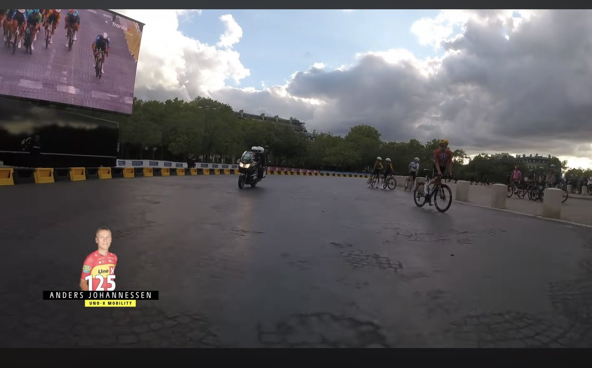 TonkeCycling's tweet photo. Onboard cameras show that riders actually stopped on the Arc de Triomphe roundabout to watch the final kilometer on the big screen. That’s pretty cool #TDF2026 https://t.co/yllCr91MHb