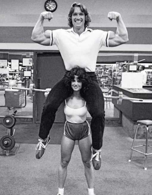 historyinmemes's tweet photo. Arnold Schwarzenegger is lifted by pioneering female bodybuilder Lisa Lyon at Gold’s Gym.

Some photographs challenge long-held assumptions, and this one remains one of the most memorable images in bodybuilding history.

Lisa Lyon wasn’t lifting Arnold Schwarzenegger simply for a photo opportunity. As one of the pioneers of women’s bodybuilding, she represented a movement that was fighting for recognition and respect. At a time when female athletes were often underestimated, the image underscored that strength isn’t defined by gender or body size alone, but by skill, dedication, and determination.

That’s why the photo continues to resonate decades later. While it appears playful at first glance, it also symbolizes a turning point in how people viewed women’s strength. Lisa Lyon didn’t just help establish women’s bodybuilding—she helped expand the world’s idea of what strength could look like.
