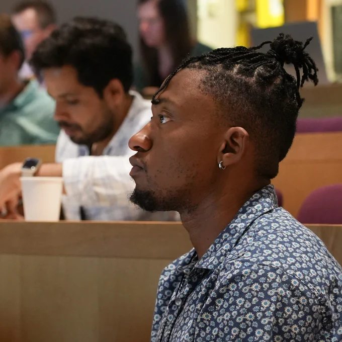 Photo of researcher in auditorium listening intently.
