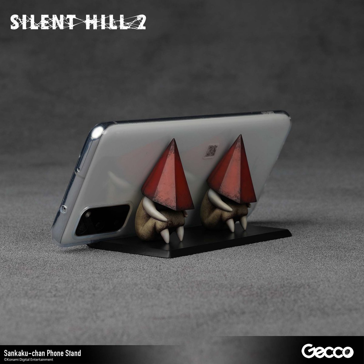 Gecco_Corp's tweet photo. SILENT HILL 2を代表するクリーチャー「レッドピラミッドシング」が、デフォルメサイズのモバイルスタンドとして登場。その名も「三角ちゃん」
本日より予約受付開始！

製品情報：https://t.co/N1ZOfqHWJY

"Red Pyramid Thing," the iconic creature from SILENT HILL 2, appears as a super-deformed phone stand, affectionately named "Sankaku-chan."
Pre-orders open today!

Product info: https://t.co/rowbfewDDF

#SILENTHILL #サイレントヒル #Gecco