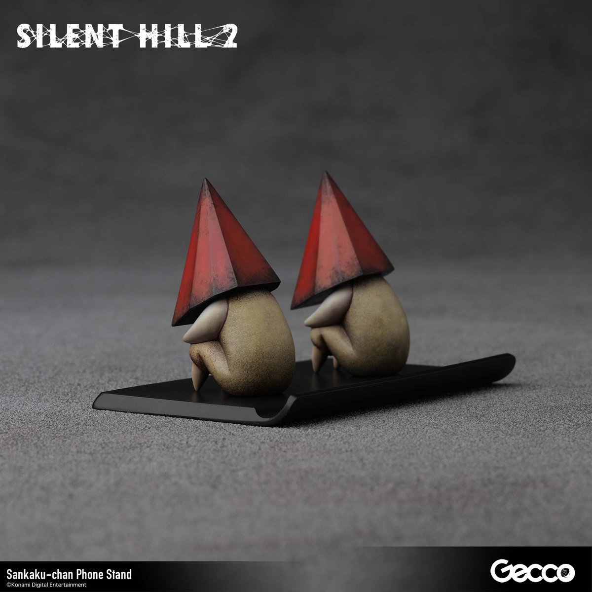 Gecco_Corp's tweet photo. SILENT HILL 2を代表するクリーチャー「レッドピラミッドシング」が、デフォルメサイズのモバイルスタンドとして登場。その名も「三角ちゃん」
本日より予約受付開始！

製品情報：https://t.co/N1ZOfqHWJY

"Red Pyramid Thing," the iconic creature from SILENT HILL 2, appears as a super-deformed phone stand, affectionately named "Sankaku-chan."
Pre-orders open today!

Product info: https://t.co/rowbfewDDF

#SILENTHILL #サイレントヒル #Gecco