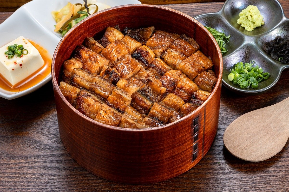 gan_nandaimon's tweet photo. 新店「うなぎの柿源」を7月25日に無事オープンできました！足掛け1年2ヶ月、テナント確保から融資、工事完了まで本当に困難が多かった。話したい事が多い中「なぜ柿源という店名を引き継いだのか？」をお伝えしたい。元々はホタテ料理で有名な柿源さんがこの場所で長年営業をされていました。しかし前オーナーの体調不良などもあり、惜しまれつつ営業は一旦休業に。

僕が新店舗テナントを探していた時に、そのような事情を前オーナーのご家族からお伺いしました。知らずにご連絡したのでとても驚きました。

・108年前に創業されて、新町通りの発展の一部始終を見守ってきたこと。

・柿源としての営業はもう再開されないということ。

・前オーナーが体調を崩されている中で、最後までお店に立たれていたこと。

色んな話を聞く中で、柿源さんは代々青森市の発展のためにご尽力されたとお伺いしました。

昭和34年当時、新町通りは屋根がなく、雪が降ったら店の前に雪が積もり、歩行者が激減、商売にならなかった。

そんな状況を変えるために「天候に左右されず買い物ができる街をつくろう」と、前オーナーや当時の新町商店街の皆様が私財をはたいて雪の降る新町通りにアーケードの屋根を作り、商店街を守った。

このアーケードは約70年前、冬でも人が歩ける街を目指した商店主たちの挑戦から始まりました。

そんな熱い歴史に、僕は胸を打たれた。

「新町通りを108年前から見守ってきた、新町の歴史そのものである柿源さんを絶対に無くしてはいけない。」

「世界に誇る青森の重要文化財と言える柿源さんの名前と魂を、青森に残さないといけない。」と強く感じました。

そこで、前オーナーとお話をする中で僕は「柿源という名前を残させていただけませんか？」と相談しました。

「業態は変わってしまうかもしれないけど、もしよろしければ、柿源という名前を僕に継がせてください。前オーナーたちのように、僕がここからまた数十年柿源の名を繋ぎたいです。」と本心で伝えました。

血の繋がりも、元々関係性があったわけでもありません。ましてや人種も違います。ですが、僕が残さないといけないと強く感じました。

僕も、柿源さん前オーナーのようにかっこよく生きたい。

口だけではなく、行動で青森をより良くできる人間になりたい。

街のために、商店街のために、そこで働く皆様のために、私財をはたいて街を作れる人間になりたい。

先人のスケールの大きさと志の高さに感動し、強烈な憧れを抱きました。

そして前オーナーも店名を残すことについて快く受けてくださいました。心と心がつながった感覚があり、本当に嬉しかったです。

体調を崩した中でもお店に出られた前オーナーもきっと、お店を残したかったんだと思います。その思いに応えたかった。

108年前から青森を守ってきた先人のように、より街のため人のために尽力しようという決意から、この度「柿源」という名前を引き継がせていただくことになりました。

その名も「うなぎの柿源」。

お昼は鰻重やひつまぶしが手頃に食べられるお店。
そして夜は居酒屋としても楽しめる大人なお店。

外観も内装も、本当にこだわりました。インパクトがあります！

ただ目立ちたい！とかそういうことじゃないんです。

「青森市新町に活きのいい粋な店がある！」
「なんだか最近、新町が元気だね！」
「楽しい通りだね、ワクワクするね」

と青森の方、そして青森を訪れた方に思っていただきたい。
元気で楽しい街だと思ってほしいし、そうやって人の流れが増えて活性化させたい。

気合いが入っていて、街に光を灯せる明るい存在になる。

そんな思いがあるので、帆立家もうなぎの柿源も、楽しくてインパクトある外観・内装にしました。

思いが通じたのか、おかげさまで南大門も帆立家も満員御礼。柿源もそうなれるように頑張ります！

その昔、街のために立ち上がり、お金を出して、街をよくした人たちがいた。

僕も、今の時代にこそ、青森の先人たちのようなかっこいい存在になる。

まずは僕が私財をはたいて新町通りのアーケードの雨漏りを直すところから始めよう。

最近、「新町通りは補助金通り。あいつらだけ補助金もらっていい思いして」と心無いことを言う人がいて、驚くと同時に悲しくなりました。

僕は目の前で言ってやりたい。
1円たりとも補助金はもらわず、自費でやってますよ。

そうやって、レッテルを貼り誰かを蹴落として自分の評価を上げても青森は何も変わらないです。口だけじゃなく、行動で証明できる人間に僕はなります。

ということで、新町通りに新しいお店がやっとできました！

鰻重 並は、2000円でお釣りがきます！✨
鰻の中では食べやすいお店です！

ご助言やアドバイスをいただきながら、より良いお店にしていきます！

「うなぎの柿源」新オープンを何卒よろしくお願いいたします！