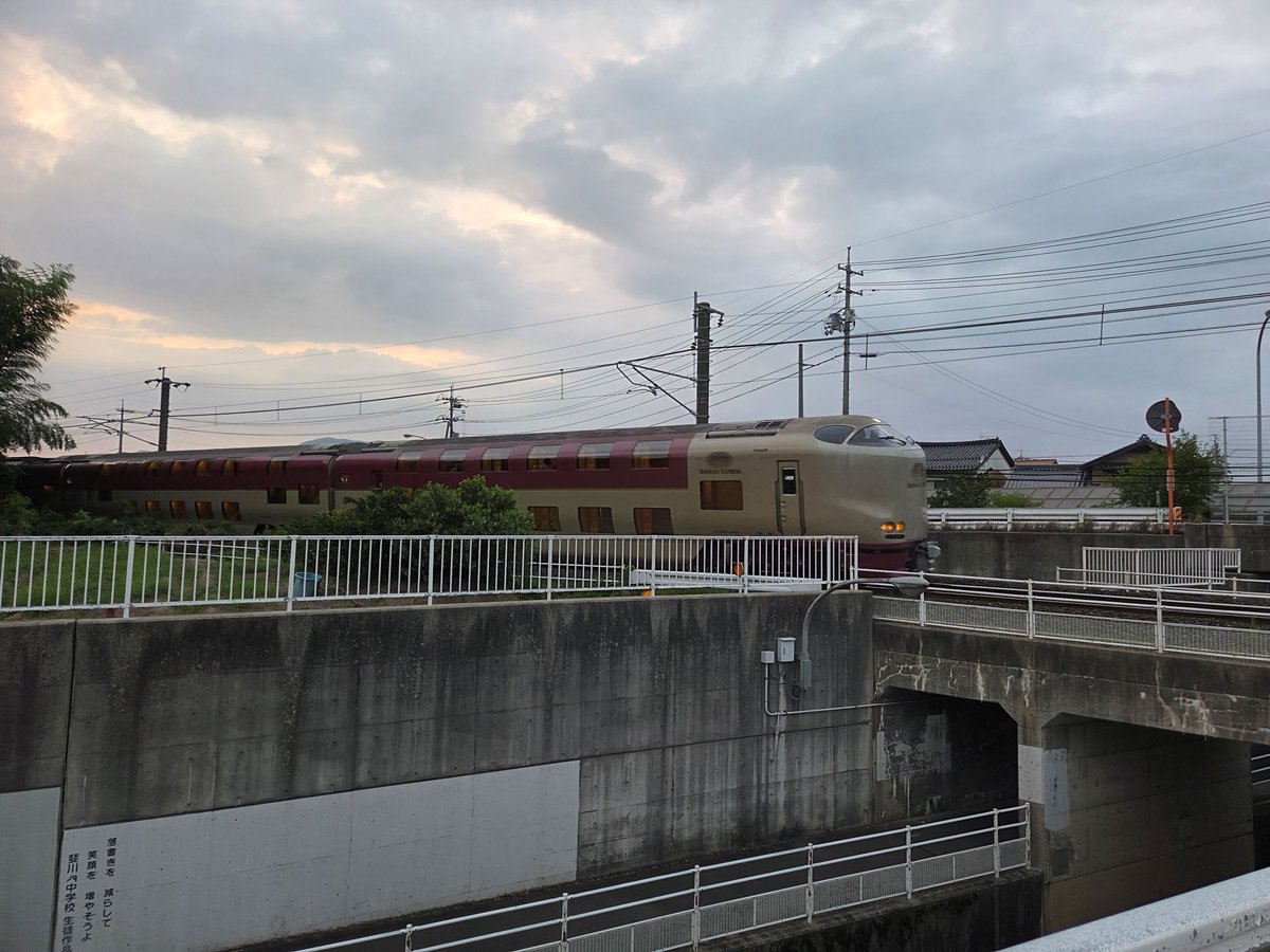 A8800454's tweet photo. 出雲市駅のウォッチングを終え、出発、国道9号線を東へと走りました。駅の北側に迂回していた国道9号線は、例の斐伊川を渡り終えたあたりから山陰線と接近します。時間は19時頃。あの18時57分発のサンライズが後ろから追っかけてきて、どこかで抜かれるのではないか、と気になり始めました。関西では、夜中にでも出かけない限り、実物にはお目にかかれません。一丁、記念にどこかで撮影を、ということになりました。交通量のない脇道に止めて撮った写真がこれです。周囲に踏切もないので、いきなり現れました。もう少し線路に近寄ればいい写真になったかもしれませんが、あまりガツガツしてマンションの人に迷惑になってもいけないと、離れた場所からにしました。小生の鉄道写真はこれでいいんです。
＃特急サンライズ