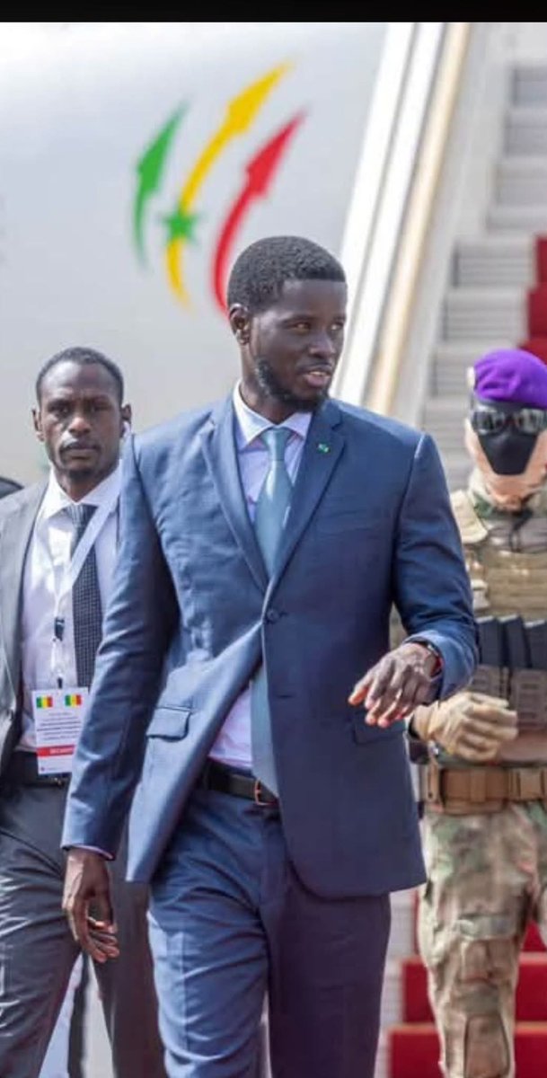 MaMaDouMaKHTaaR's tweet photo. Outfit du président lors de son voyage au Mali a fait l'objet de nombreuses critiques et de moqueries, celles-ci ne sont pas fondées.

Gayi aka gno deugueur fit té khamou gnou dara.

Le costume répondait à des codes précis, parfaitement adaptés au contexte.

Coupe moderne veste bi met particulièrement en valeur sa carrure.

Le choix du bleu marine associé à une cravate assortie offre un rendu à la fois professionnel, sobre et charismatique.

Costume bi dafa froissé 🤣 

Les matières estivales (laine fine, lin, coton) se froissent inévitablement lors des déplacements en avion ou en voiture.  

Je lui conseille soit de se changer à bord de l'avion présidentiel à l'instar de nombreux chefs d'État soit d'embarquer un défroisseur à vapeur afin d'arborer une tenue impeccable dès sa descente d'avion. 

Marcher, descendre des marches ou sortir d'un véhicule crée naturellement des plis d'aisance au niveau de la taille et des cuisses.

Une coupe cintrée et ajustée marque plus rapidement les mouvements du corps, ce qui est tout à fait normal mo waral poitrine mélni lou froissée. Mo waral veste bi pliée wou si biir ak ngélaw li.

Tout n'est pas parfait, je suggère au tailleur du président @PR_Diomaye :

De retravailler le col du costume pour lui donner un revers plus généreux.

Rallonger d'environ 2 cm la longueur de la veste pour parfaire la ligne.

Ajouter 1 cm les manches de la chemise pour qu'elles dépassent idéalement de la veste.

MAMADOU MAKHTAR DIOP