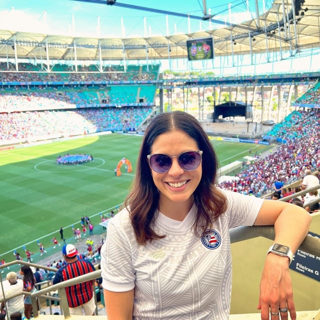 Esp_Bretao's tweet photo. Clara Albuquerque, jornalista da TNT Sports, contou no Bar FC como virou torcedora do Bahia. 

E a história não começa com o Bahia.

Os pais tomaram a decisão de não influenciar os filhos em grandes escolhas de vida. Religião, profissão, time de futebol. 

Clara cresceu sem ser catequizada para nenhum lado. 

A família do Rio de Janeiro não pensou o mesmo. 

A primeira camisa de futebol que ela ganhou foi do Vasco. Achou que era vascaína.

Quando começou a entender mais de futebol percebeu que havia algo diferente quando o Bahia entrava em campo. A confirmação veio na final do Baiano de 2012, Bahia 3x3 Vitória em Pituaçu. 

O clube tinha dez anos sem ganhar título estadual. Quando o jogo terminou ela chorava. 

"Caramba, eu sinto algo por esse clube que é diferente."

Com 29 anos foi para o Rio de Janeiro. Escreveu um livro sobre os dez maiores ídolos do Bahia. 

O que começou como pesquisa jornalística virou reconexão pessoal. À medida que pesquisava e lia sobre cada ídolo, foi se apaixonando pela história do clube. Pelo que cada um representou. 

Pelo tamanho do que o Bahia significa para Salvador.

Clara nunca foi a baiana típica. Não se identificava com praia, carnaval, com o estereótipo de Salvador. 

Passou quase 30 anos com a sensação de que faltava um pedaço. Morou fora do Brasil por cerca de dez anos.

O Bahia preencheu esse espaço.

"Eu passei quase 30 anos da minha vida com a sensação de que faltava um pedaço de algo. E o Bahia foi aquele laço. O gatilho para dizer: essa raiz tá aqui."

Hoje a ligação dela com o clube vai muito além do futebol. É pertencimento. É identidade. É Salvador.

🎙️ Bar FC link abaixo
#Bahia #EsquadrãoDeAço #futebol #Salvador
