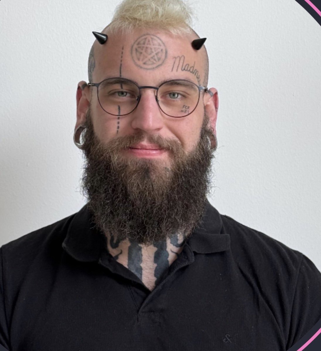 Erzbischof2023's tweet photo. Also ganz harmlos scheint mit der Typ nicht zu sein. Vor allem der Konnex zwischen Madness und Okultismus wird in der Literatur schon vielfach angesprochen. Teufelshörner plus Pentagramm und Madness scheint mir doch nicht ganz uneindeutig zu sein. 

"Es gibt zudem Bücher und okkulte Texte zu „Demons of Madness“ oder ähnlichen Motiven im theistischen Satanismus, die Wahnsinn als kreatives oder magisches Potential behandeln. Im Black Metal (besonders der skandinavischen und extremen Szene) werden Satanismus, Chaos, Nihilismus und „Madness“ häufig als ästhetische und provokative Motive verwendet. 

Ein konkretes Beispiel ist das Album Carelian Satanist Madness (2005) der finnischen Band Satanic Warmaster – ein Raw-/True-Black-Metal-Release mit satanistischen, dunklen und teils nationalistisch angehauchten Themen. Der Titel spielt auf regionale (karelische) und extrem-satanistische Motive an und bezieht sich teilweise auf frühere Releases wie Absurds Thuringian Pagan Madness. 

Solche Werke nutzen „Madness“ als Bild für radikale Ablehnung, Aggression und okkulte Atmosphäre, nicht als klinische Beschreibung."