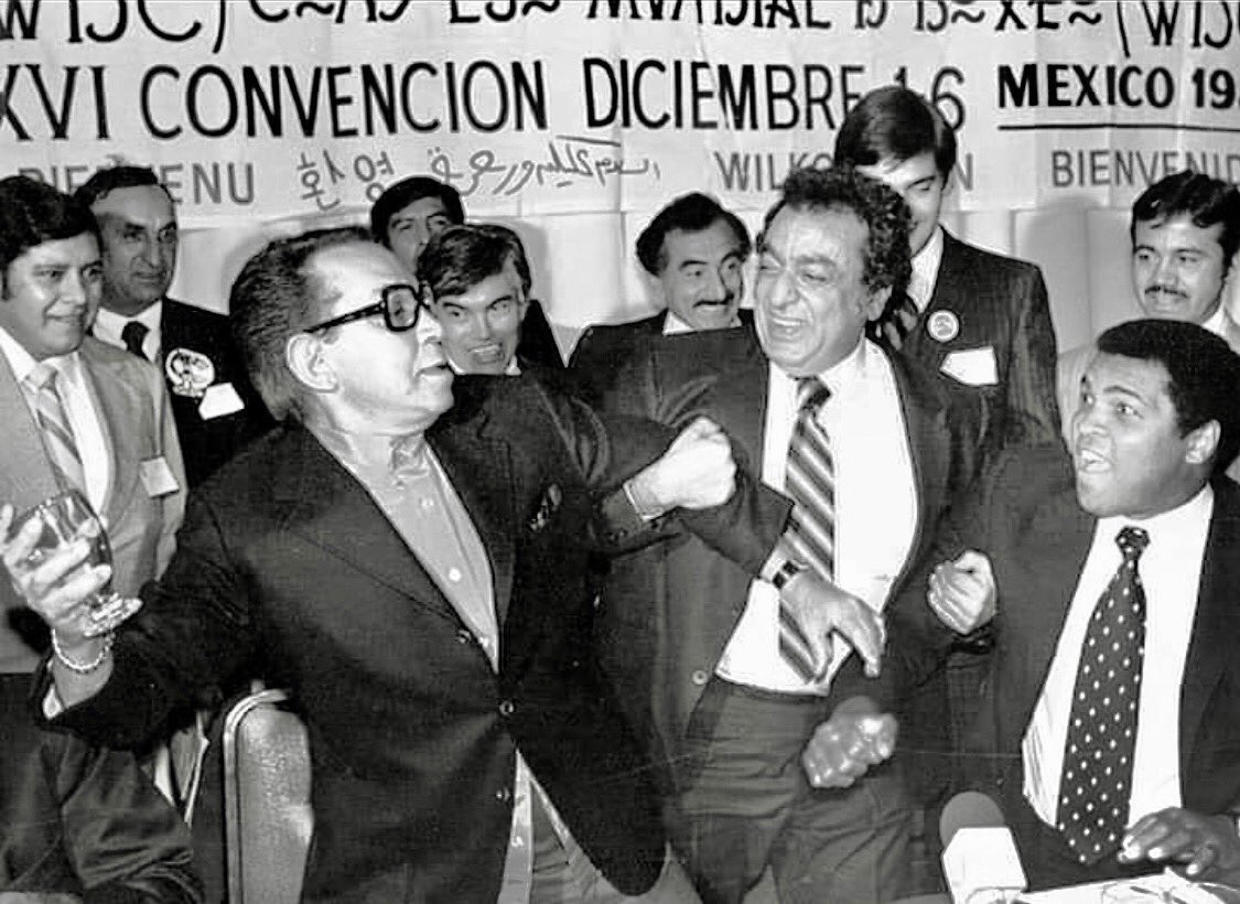 Cuauhtemoc_1521's tweet photo. Sabías que Cantinflas “retó” a Muhammad Ali en la Ciudad de México?

Esta extraordinaria fotografía fue captada en diciembre de 1980, durante una Convención del Consejo Mundial de Boxeo (CMB) celebrada en la Ciudad de México. En ella aparecen tres figuras legendarias: Mario Moreno “Cantinflas”, Muhammad Ali y José Sulaimán, presidente del organismo que transformó el boxeo mundial. En medio de un ambiente de camaradería, Cantinflas protagonizó uno de los momentos más memorables del evento al desafiar, en tono completamente humorístico, al campeón estadounidense. Incluso le reclamó que “no quisiera pelear con él” y, siguiendo su característico estilo cómico, tomó un vaso e hizo el ademán de lanzárselo, provocando las risas de los asistentes. José Sulaimán intervino como improvisado “réferi” y mediador de aquel singular encuentro.

Aunque Muhammad Ali jamás disputó una pelea profesional en México, visitó el país en diversas ocasiones gracias a la estrecha amistad que mantenía con José y Elías Sulaimán, quienes lo recibían con frecuencia en eventos relacionados con el boxeo.
