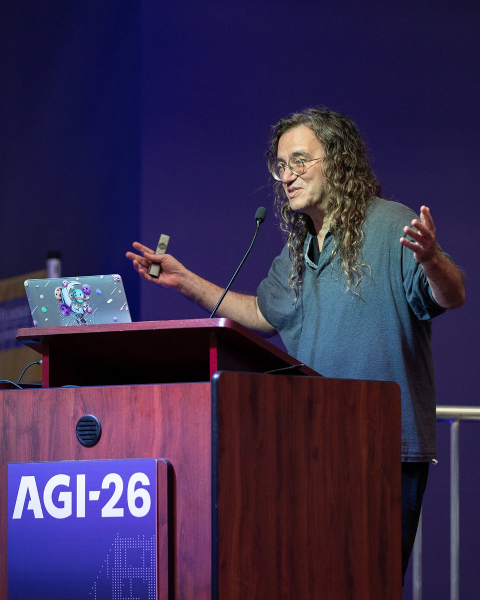 SingularityNET's tweet photo. CEO Dr. @bengoertzel presented his AGI-26 paper "Quantum Logic Networks: PLN-Style Inference in the Operator Evidence Algebra."

The paper introduces Quantum Logic Networks (QLN), a framework that extends Probabilistic Logic Networks (PLN) by representing truth values as quantum operators and inference rules as completely positive trace-preserving maps.

QLN is proposed as the right reasoning substrate for AGI systems that must cope with genuinely complementary propositions, entangled evidence sources, and non-commutative belief updates. The paper also sketches a hybrid quantum-classical implementation path via a block-diagonal regime that is tractable on near-term hardware.