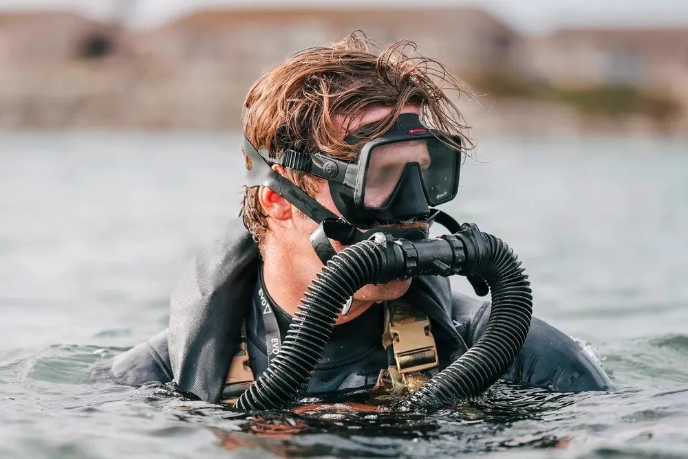A Special Forces Soldier looks around in goggles. 