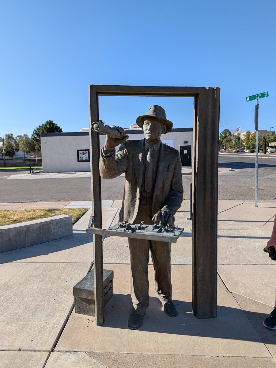 ashleevance's tweet photo. This might just be the peak of American statues. It's Robert Goddard across the street from a Wendy's in Roswell, New Mexico. 

It's the 1920s and this lunatic is telling people rockets can get to space and the moon and Mars. The NYT writes a piece saying he's the bad kind of lunatic and not the good kind because the physics will never check out on something flying in a vacuum. 

He starts making liquid fueled rockets anyway. First on the East Coast and then he heads to New Mexico in 1930 because America is grand and has grand lands where you can blow things up in peace. 

The Russians and the Germans will get there soon, but Goddard got there first. 

Look at the statue. Fingers ready to ignite. He's looking towards his test stand, sure, but he's also looking toward a future no one else can conceive of. Coat. Tie. Hat. Perfect.