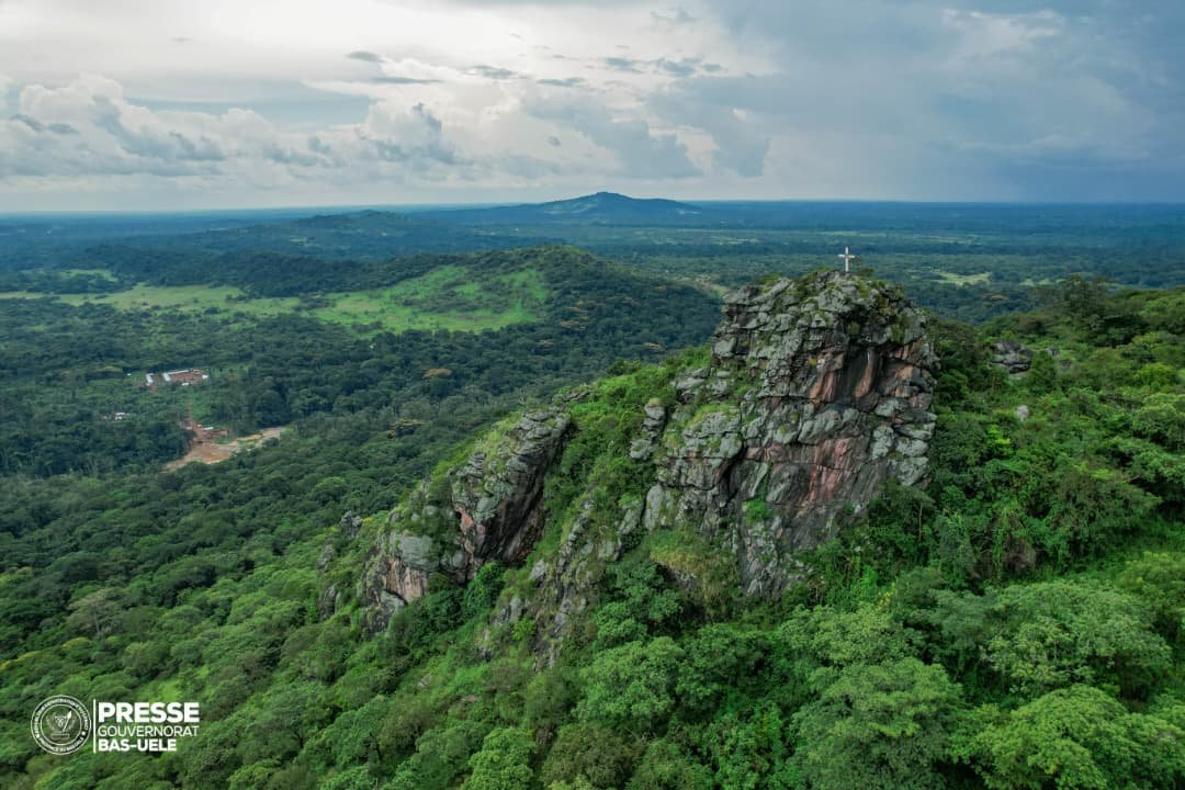 sergesindani01's tweet photo. 🔴#RDC—— Au Bas-uelé, à la découverte d'une chaîne de montagnes aux mille mystères

Dans le groupement #Madi, territoire de #Poko, au #Bas_Uélé, voici l'un des sites les plus impressionnants : une chaîne de montagnes dont l'accès exige près de quatre heures de marche à travers un relief escarpé. Au sommet se dresse une imposante croix, devenue un symbole marquant du lieu. Pour de nombreux visiteurs et habitants, cette montagne est un espace de recueillement où l'on ressent une profonde sérénité et une forte dimension spirituelle.

Cette découverte illustre la richesse naturelle, touristique et culturelle encore méconnue du #Bas_Uélé. Le Gouverneur @mikemokeni y a été pour une visite, à travers laquelle, il a réaffirmé sa volonté de faire connaître les trésors cachés de la province et de les inscrire dans la dynamique de développement et de valorisation voulue par le Président de la République.