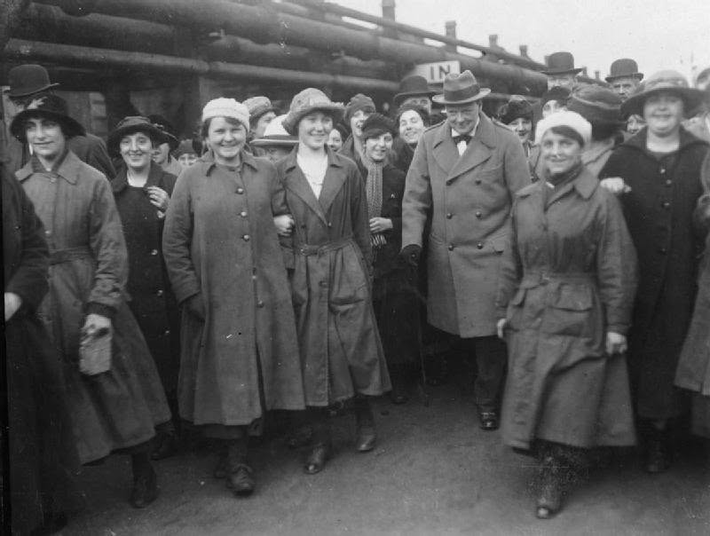 NPWH2022's tweet photo. 📸2. The Minister of Munitions Winston Churchill is escorted through the yard of Georgetown's filling works near Glasgow by female workers during a visit on 9 October 1918. https://t.co/tmAsZrExuJ