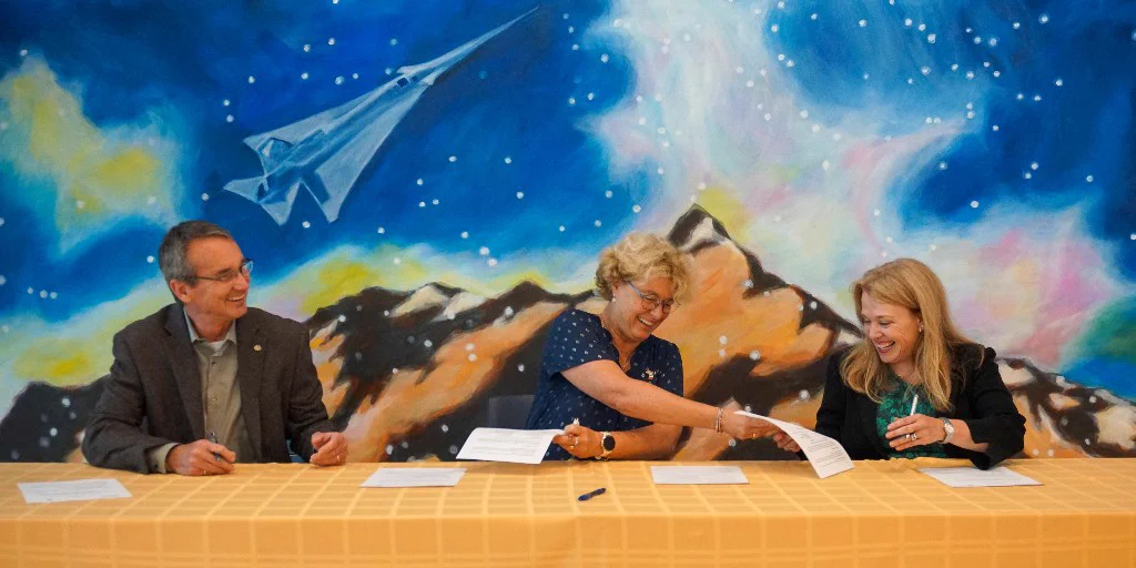 Exchanging printed copies of the MOU at the signing. From left: Keith Molenaar, dean of the College of Engineering and Applied Science; Marie-Hélène Baroux, director general of ISAE-SUPAERO; and Jill Blondin, vice chancellor for global affairs.