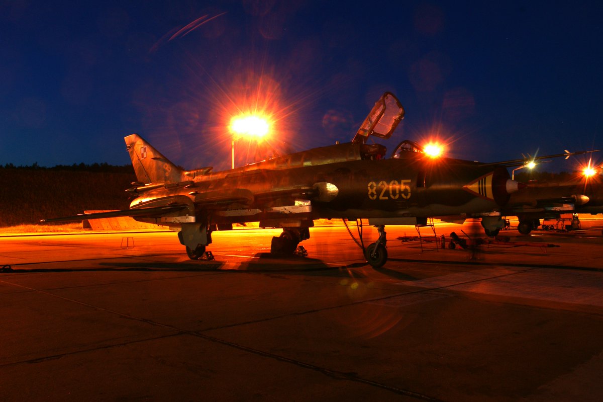 MichaFiszer's tweet photo. Nie byłem pilotem myśliwskim. Byłem od demolki na ziemi.

Lubiłem to. Wyobraźcie sobie salwę 128 rakiet niekierowanych z czterech pełnych zasobników UB-32. Wchodzicie w nurkowanie, zapusk lasera, przełącznik na S-60 na drążku marka celownika na cel, obserwujecie skalę odległości na szybie celownika, wchodzi w strefę dozwolonego ognia, zielona lampka na celowniku, więc dociskacie odbezpieczony już przycisk "podwieski".

I słyszycie takie dźwięki, jakby ktoś otwierał 132  butelki szampana. Takie pum-pum-pum, taki głuchy dźwięk jak otwierana butelka. Takie dziwne trochę. Nie tak jak z działek, kiedy huk wystrzałów wstrząsa wami do szpiku kości, samolot drży, a w kabinie pojawia się smród spalonego prochu, bo niewielka część dymu zasysana jest do wlotu do wentylacji kabiny. Tylko właśnie takie głuche pum-pum-pum!

Przed samolotem pojawia się cała kupa ognia i dymu. W sekundę zasłania Wam to cały widok do przodu, ale nie można spękać, bo jak zaczniecie wyprowadzać, to wysiejecie rakiety daleko za poligon, a one cały czas lecą: pum-pum-pum! I lecicie w ten ogień i dym kuląc się odruchowo w kabinie, jakby Was miało poparzyć, nie widać już ziemi. To tylko dwie i pół sekundy, zaraz przestaje "pukać", wszystkie 128 rakiet poleciało. Puszczacie przycisk "podwieski" i wyprowadzacie ostro, bo pod Wami za chwilę rypnie na ziemi 132 rakiety wywalając odłamki w niebo. Przeciążenie wgniata Was w fotel, ale trzeba drzeć w górę, trzeba przelecieć nad tą chmurą odłamków która Was goni, a każdy z tych odłamków ma szansę zamienić Wasz samolot w spadający wrak lub kulę ognia. Kiedy przed sobą widzicie już tylko niebo, idąc ostro w górę, 5-7 sekund po tym jak zaczęliście opróżniać bloki rakiet UB-32, można złapać powietrze: jeszcze raz się udało! 

Odchodzicie w bok i wtedy możecie popatrzeć: tam gdzie był wasz cel jest teraz wielka kupa dymu i kurzu, dymu który zamienia się w coraz wyższy słup. Czy jest coś lepszego co można robić w piątkowe popołudnie?

Ale latałem też na przechwycenia. Jako bombol, nie miałem radaru, korzystałem z nawigatora naprowadzania, który wyprowadzał mnie na cel, wyprowadzając w jego tylną półsferę, gdzie rejestrowałem parametry odpalenia imitatorem pocisku rakietowego na podczerwień UZR i robiłem ze dwa ataki na "foto" jak bym strzelał z działek. Raz goniłem cel, bo był daleko, włączyłem sobie dopalanie na wysokości 6800 m i nagle coś mi nie pasuje: prędkość przyrządowa prawie 900 km/h, ale rzeczywista... Rzeczywista jakieś1400 km/h, rzut oka na Machomierz i o kuuźwaa!! Ma=1,3. Ja pierdylę...  No to szklarze zacierają ręce, gdzieś pod Chojnicami poleciały szyby w całej okolicy. Wyhamowałem do poddźwiękowej jakoś i dokończyłem przechwycenie. Ale co usłyszałem od dowódcy nie będę powtarzał. Gdyby usunąć słowa uznane za nieprzyzwoite, to nic nie powiedział.

A teraz wyobraźcie sobie F-16C idącego ze strefy CAP (Combar Air Patrol) w stronę granicy skąd lei wrogi pocisk. Na ekranie radaru ma nadlatujący pocisk, prędkość zbliżania to 1800 km/h, zbliża się do niego pół kilometra na sekundę. Dwie sekundy i jest kilometr bliżej.

Idealne warunki do odpalenia AMRAAM na czołowej, echo na dopplerowskim radarze jest pewne i wyraźne, nawet na tle odbić od ziemi, jak pilot podkręci zakres MTI (Moving Target Indicator).

Jak by była wojna to trzeba zrobić dwie rzeczy. Krzyknąć do kolegi Ukrainca po drugiej stronie granicy: break, break, break, sharply to south-east, go south-east! (albo north-east), w zależności od ułożenia obu myśliwców i celu. Musi zejść z linii strzału, bo co jak rakieta AMRAAM zgubi w czasie lotu śledzenie celu i zrobi "lock-on" na ukraińskim F-16? Niech spada jak najdalej! Tylko kuźwa nie pod kątem prostym, bo wejdzie w zakres "blind speed" i zniknie Wam z radaru, bo to radar dopplerowski. Ale miejmy nadzieję, że wie o tym, pamięta i pójdzie skosem, żebyście widzieli, jak się oddala ze strefy ognia.

AMRAAM leci do celu na czołowej, choćby z bliska, z20-30 km kiedy na wszelki wypadek puścimy go na zakresie "LBL" (Lock-On Before Launch), blokując mu głowicę na celu, żeby mu nie przyszło do głowy uchwycić coś innego, niż ruski pocisk. Poszedł! I za chwilę słyszycie nawigatora w słuchawkach: kill confirmed, break left! I po sprawie. Wracacie i macie zaliczony "kill", zestrzelenie.

Ale jest pokój. Wyprowadza Was nawigator ze strefy CAP (Combat Air Patrol) i wydaje polecenie: "execute Vi-aj-di! Angel twenty zero-zero" (angel to wysokość celu w kodzie "myśliwskim, 2000 to stopy, 600 m) Odpowiadacie: "roger, going visual, vector me!" (kieruj  mnie). Nawigator odpowiada "heading nine-zero, maintain speed". Prowadzi Was w bok od nadlatującego celu. Zanim się zrównacie "Viper one, hard left for two seven zero! Execute now!" Kładziecie samolot ostro w lewo zawracając o 180 stopni, na kurs zachodni (270), a poświata księżyca oświetla leciutko ziemię gdzieś za lewym skrzydłem. Widać na ziemi pojedyncze światła, poza tym ciemno, tylko czerwona poświata od przyrządów i ekranów. 

I znów nawigator: "bandit two o'clock, distance six! Czyli 9-10 km przed Wami, lekko z prawej, bo te sześć to mile morskie. Wyświetlacie na ekranie po prawej IIR z zasobnika Sniper przełączając zakresy zobrazowań MFD (Multi Function Display) , włączacie zakres slave zasobnika. Radar macie na TWS (Track While Scan), tak by po uchwyceniu celu od razu przeszedł na śledzenie, ale żeby nie gubić z pola widzenia sytuacji powietrznej. Potwierdzacie, że Wasz prowadzony zawrócił za Wami i jest gdzieś z prawej, z tyłu, osłania Was. W każdym razie nie plącze się przed Wami, bo jak będzie "positive VID", to dostaniecie komendę na otwarcie ognia. Radar złapał cel i na "slave mode" skierował oś optyczną zasobnika na niego. 

Na ekranie majaczy wam połyskująca, zamazana sylwetka rakiety skrzydlatej. Krzyczycie do nawigatora: "Eagle, Viper one, VID positive, VID positive!" I nawigator woła podniesionym głosem "cleared hot, cleared hot! Take it!" Obramowanie na wskaźniku HUD zapala się na czerwono, w słuchawkach wyje - jest "Lock"! Drżącą ręką naciskacie przycisk odpalenia na bocznym drążku sterowym, AMRAAM z wyciem opuszcza wyrzutnie na końcu skrzydła, błysk silnika ciągnącego kitę ognia oślepia Was. Mrużycie oczy, bo przez ten cholerny ogień gówno widzicie, odruchowo drążek na siebie, do góry, do góry! Dalej od ziemi. Nawigator krzyczy: "Kill confirmed!" Break, break!" Odchodzicie w bok, by nie wlecieć we fruwające szczątki. Można wracać do Łasku albo z powrotem do strefy dyżurowania CAP.

A teraz popatrzmy. Jest wojna, idziecie na czołowy (head-on BVR - Beyond Visual Range Engagement). 20-30 km od granicy i pocisk spada.

Jest pokój, dostajecie komendę na VID. Zrównujecie się z celem 50-60 km od granicy. Po zwrocie o 180 stopni pocisk jest już ponad 70 km od granicy. Radar go szuka, jest! Jakieś 90 km od granicy. Teraz na ekranie obraz ze Snipera, jest! Mam positive VID, pocisk 100 km od granicy. Jest zgoda i odpalacie pocisk, 110 km od granicy. Dostał, 120 km od granicy, spadł. I gitara! Ale de facto spadł 92 km od granicy sam z siebie, nim opisana sekwencja została zakończona. A wg. gen. Nowaka brakowało do końca 1-2 minuty.

A wiecie dlaczego mu wierzę? Bo jak to rozliczyłem  minuta po minucie, to mi też tak wyszło. Dokładnie, 1-2 minuty.

VID powoduje że potrzebujecie dodatkowych pięciu minut, na dolot do niego (dwie minuty), zwrot (minuta), ponowne przechwycenie na radarze po zwrocie i skierowanie osi optycznej Snipera (minuta), zgodę na strzał i sam strzał (minuta), razem 5 minut. 80-90 km dalej od miejsca 20-30 km od granicy kiedy został przez Was uchwycony na radar po raz pierwszy, i kiedy mogliście zrobić Head-on BVR, gdyby była wojna, zdjąć go tam.
Ale nie ma wojny. I chyba dobrze, nie?
Jak doczytaliście do tego miejsca, to jesteście zuchy! Nie usnęliście?
No to super!

Na zdjęciu Su-22 w czasie nocnych lotów, Świdwin
Fot. Michał Fiszer

Jeśli chcecie, żebym poświęcał swój czas na te wpisy, jeśli w ogóle chcecie je czytać, to poproszę o kawkę. To tylko kilka złotych, a mnie rekompensuje włożony w tę pracę czas.  https://t.co/pPHnCSlNfq