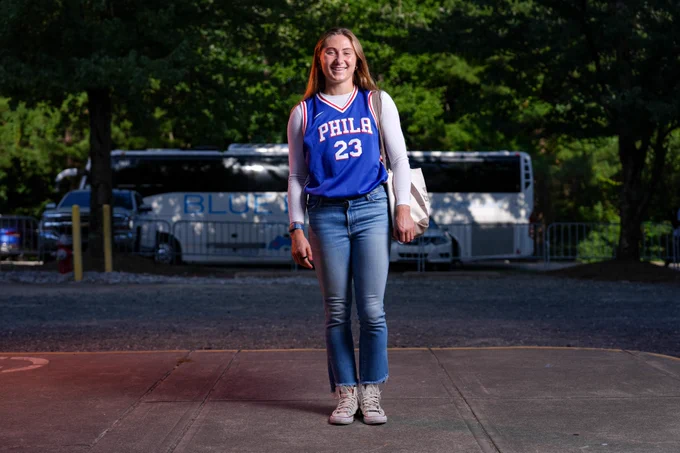 Ally Schlegel arrives to First Horizon Stadium wearing a blue 76ers jersey
