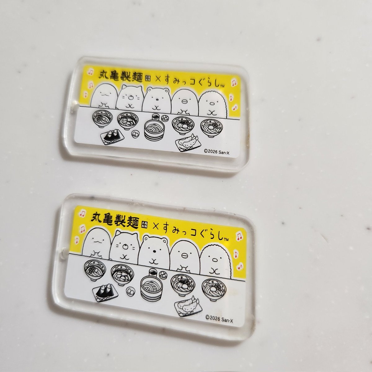 namele7's tweet photo. うどん弁当パッケージキーホルダー、どちらもなぜか平行四辺形…もう1個は本に挟むときに丸まってしまった😢難しい… https://t.co/eSVlRuCow2
