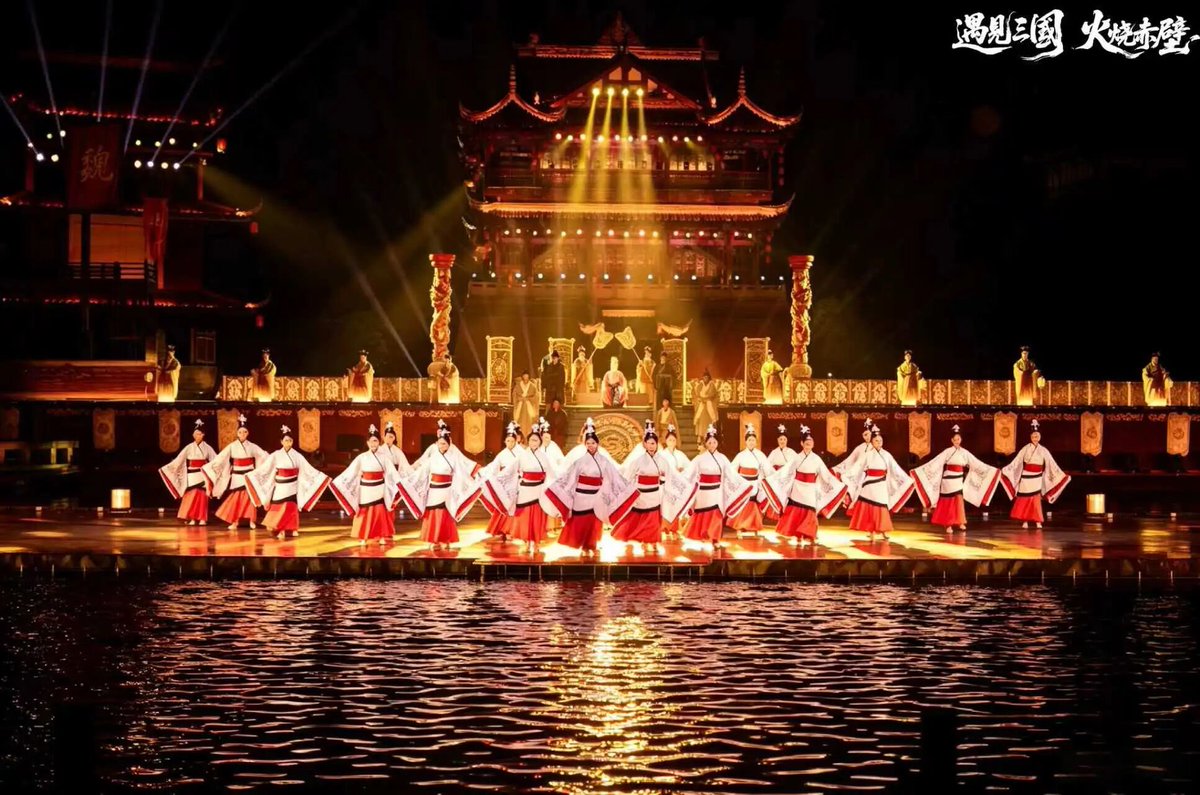 syansyan2023's tweet photo. 【四川成都で大型実景ショー『出逢い三国・赤壁の戦い』がスタート】

7月3日、四川省成都市龍泉駅区の洛帯古鎮にある「出逢い三国劇場」にて、大型水上実景演芸『出逢い三国・赤壁の戦い』が初演を迎えた。2000人を超える観客が、水と炎が織りなす圧倒的な空間の中で、1800年の時を超えた三国志の戦火の伝説を目撃した。

全編約60分の本作は、洛帯という地名の由来や、当地と深く関わる歴史人物・劉禅を物語の冒頭と結末に据え、劉禅の一瞥をきっかけに「銅雀台の出兵」「孫劉同盟」「草船借箭（草舟借箭）」「赤壁の火攻め」といった宏大な叙事詩の名場面を展開する。同時に、若き兵士アロという一人の小さな人物の生涯に焦点を当て、従軍のための故郷離れ、母との別れ、国家統一の平和のために奮戦する姿、そして最後の里帰りまでを描くミクロな感情描写を重層的に交差させる二層構造の叙事となっている。

今回の初演により、成都市東郊外における大規模なナイトエンターテインメントの空白が埋められただけでなく、三国志文化・客家文化と水上実景演出が深く融合。今後、毎年50万人以上の夜間集客増が洛帯古鎮にもたらされる見通しだ。