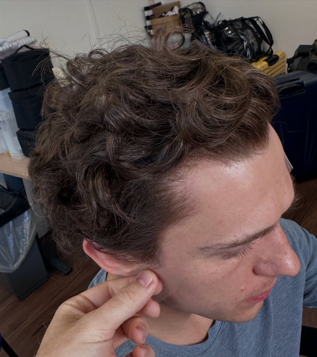 tomhollandbr's tweet photo. O cabeleireiro e especialista em perucas Samuel James Wigs compartilhou algumas imagens do Tom Holland nos bastidores de "Homem-Aranha: Um Novo Dia".

Em publicação nas redes sociais, ele confirmou que sua equipe criou uma peruca com cachos naturais para recriar o visual de Tom Holland em uma cena de flashback do filme, no qual o profissional não sabe se entrou para o corte final do filme.

📸: samuel_james_wigs_