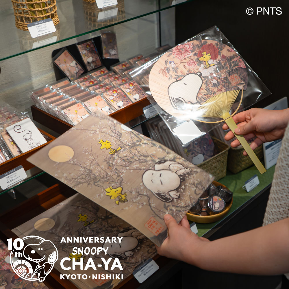 Snoopy_chaya's tweet photo. 本日8月1日(土)より #SNOOPY茶屋 京都・錦店の開店10周年を記念して新商品やノベルティ、記念メニューなどがスタート！

一部ご紹介♪

京都・錦店10周年記念[漆黒のスヌーピーやき]はテイクアウト限定で販売。
2F #WOODSTOCKNEST にはイートインスペースもあり、ちょっとした休���にもおすすめです♪

さらに、10周年を機に、錦市場にゆかりを持つ画家：伊藤若冲の作品と、PEANUTSのアートがコラボレーションした特別なデザインの商品も登場！
今の時期にぴったりな竹うちわや、コレクションしたくなるアイテムなどをご用意しています。
そのほかにも、京和傘を持ったかわいいスヌーピーのマスコットや、錦市場の魅力をぎゅっと詰め込んだ新商品が盛りだくさん♪

そしてご来店いただいた際は、10周年を記念した来店記念スタンプもお忘れなく！

皆さまのご来店を心よりお待ちしております。

#snoopy #peanuts #スヌーピー茶屋 #錦店 #10周年 #スヌーピーグッズ #史努比 #花生